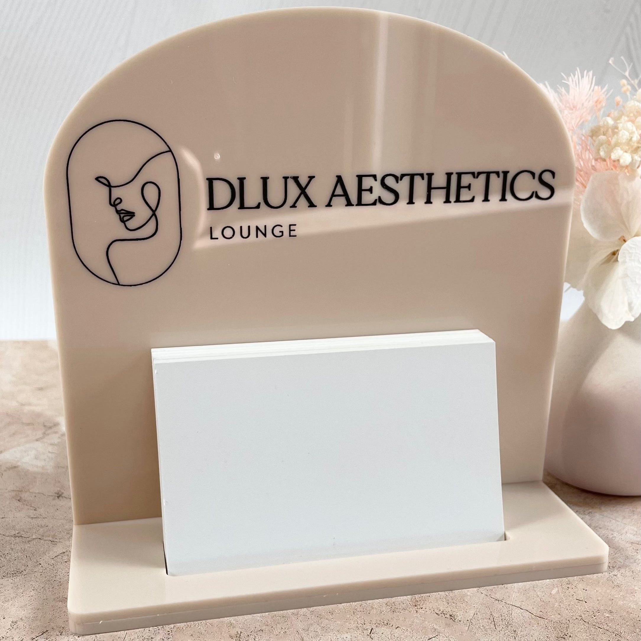 Neutral acrylic card stand with DLUX Aesthetics logo
