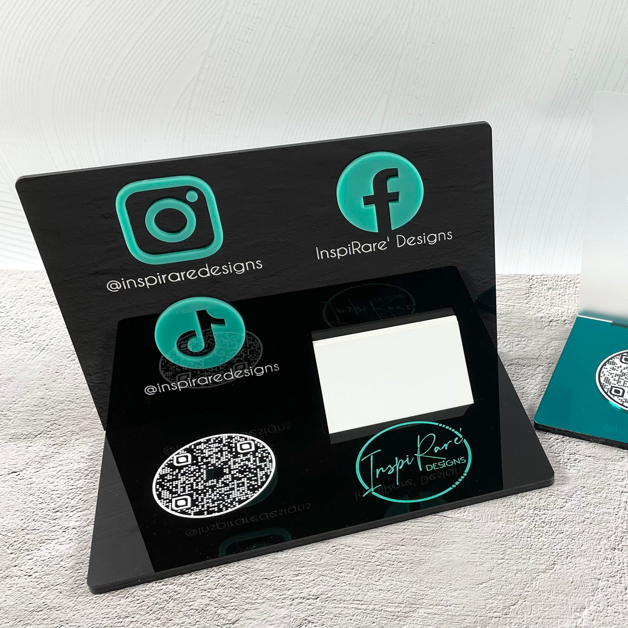 Black acrylic social media sign with turquoise icons and card slot
