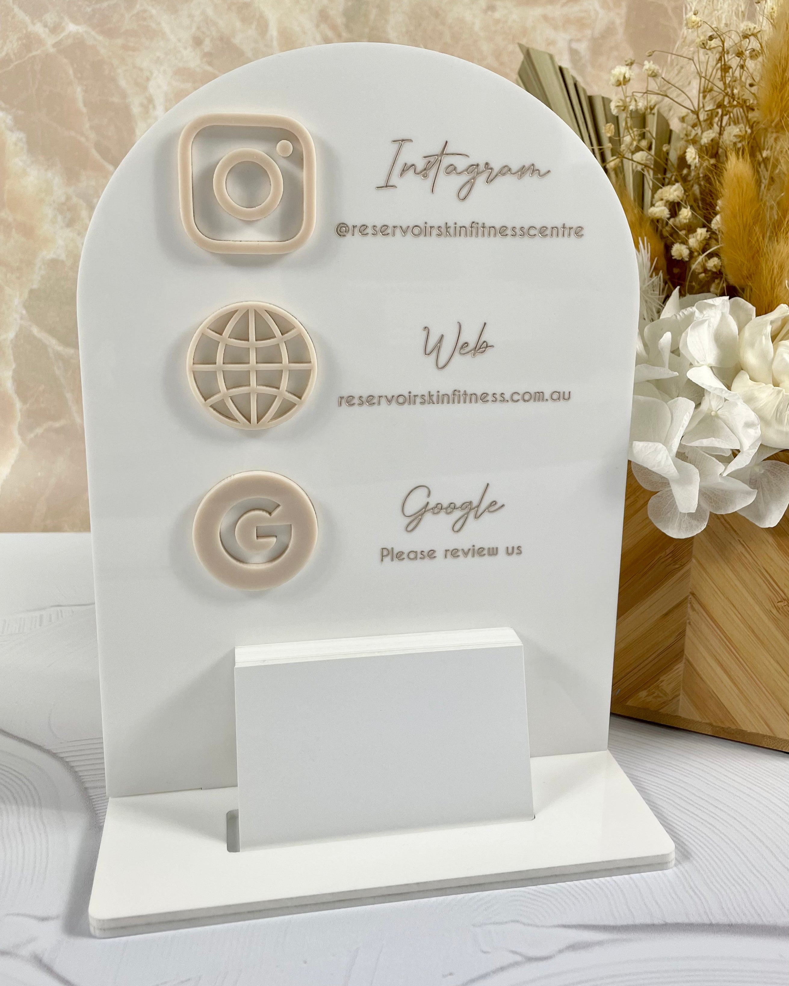 White acrylic salon display with stacked social icons and Instagram handle