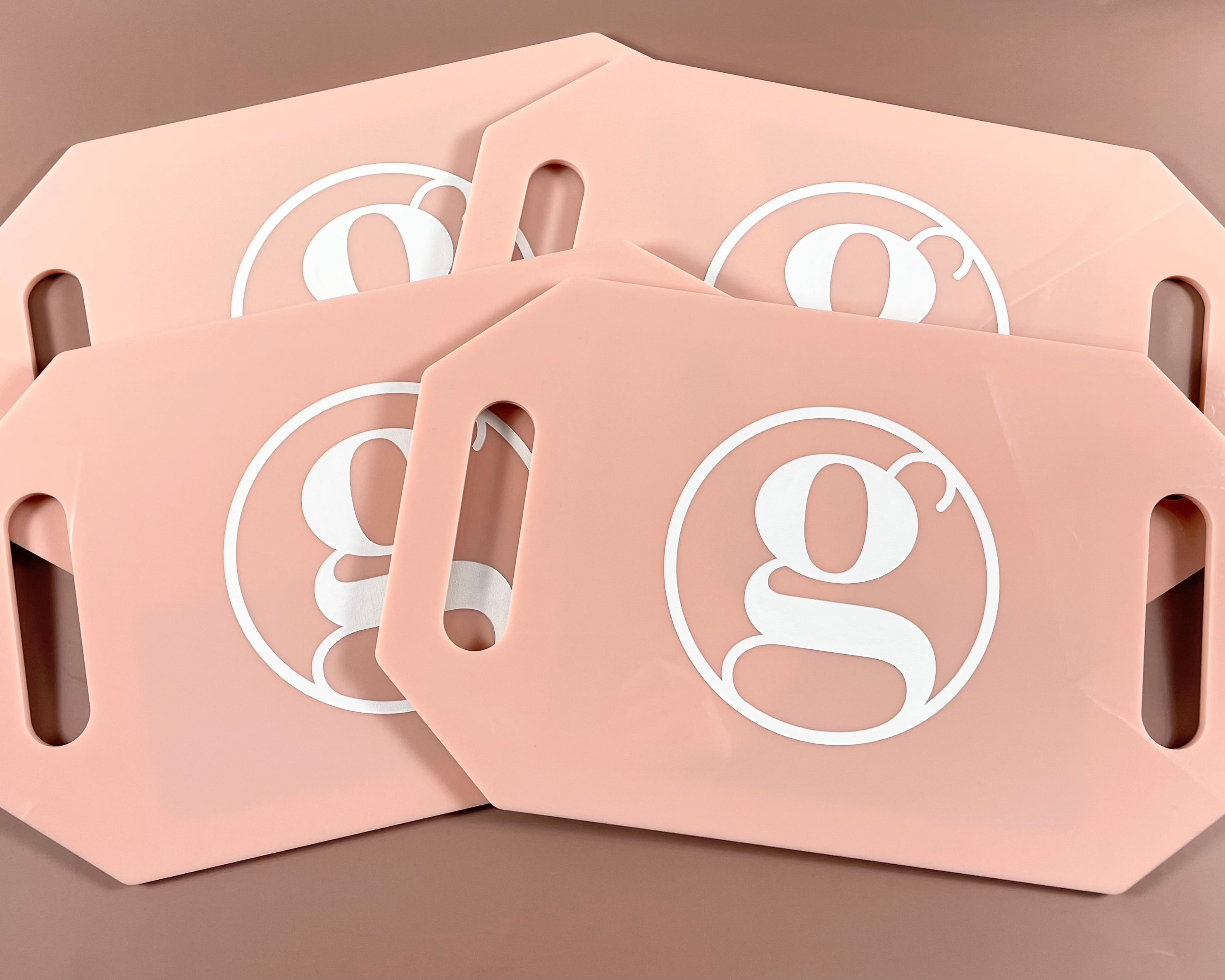Set of peach coloured branded mirrors with circular g logo