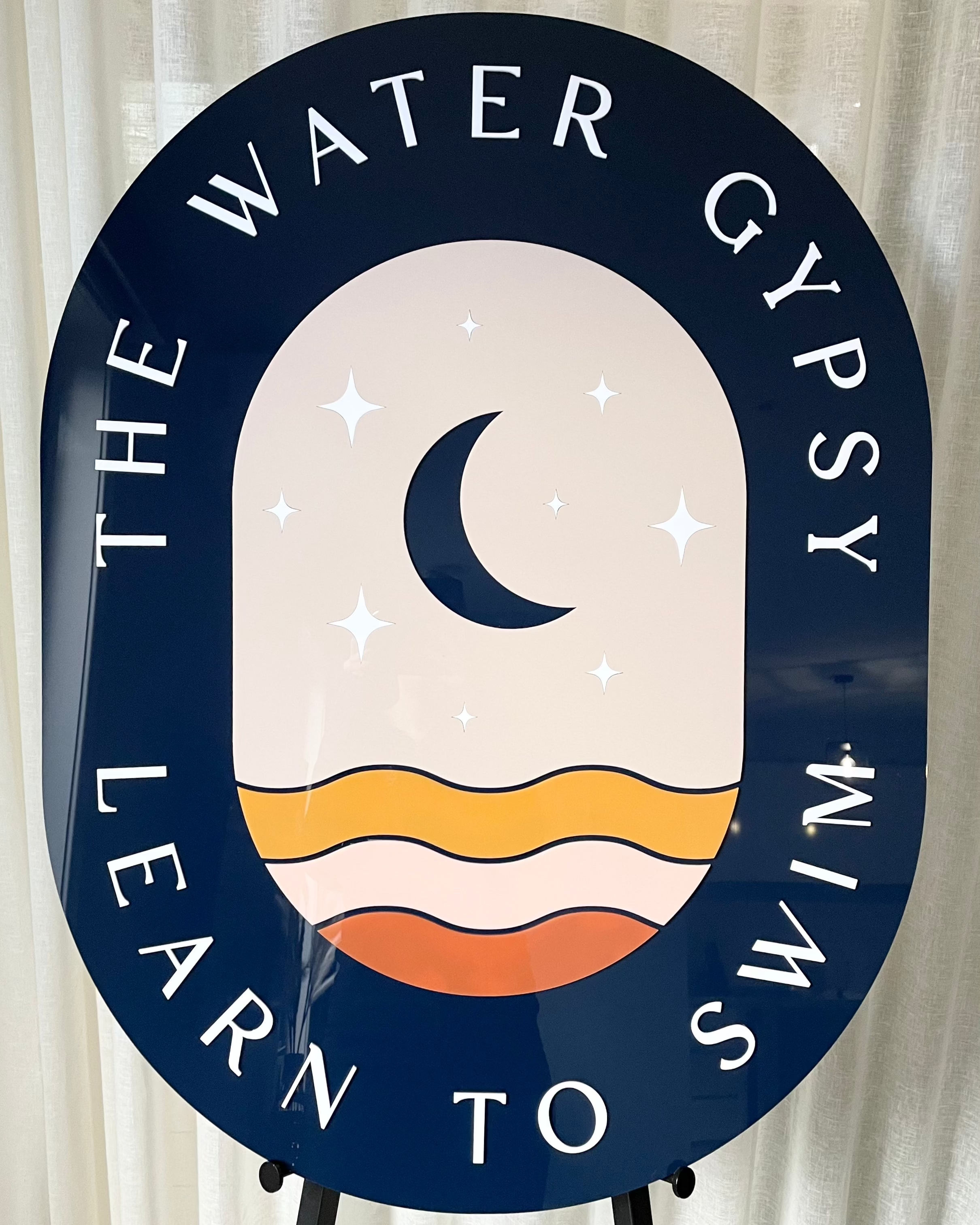 Navy and peach swim school sign with moon logo