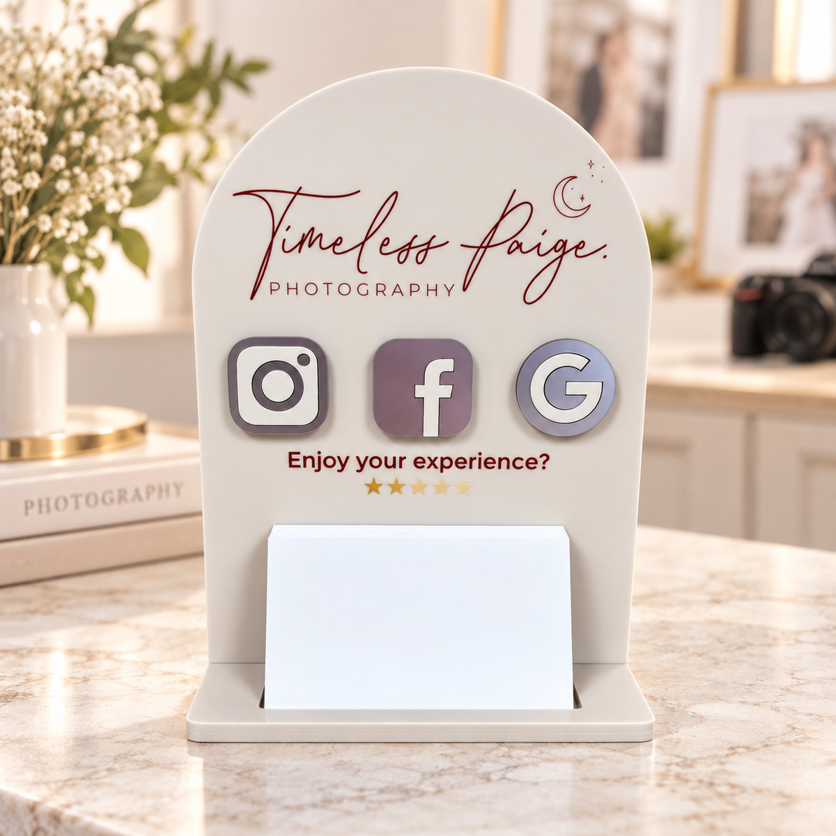 Custom acrylic social media and Google review stand for a photography studio, featuring Instagram, Facebook and Google icons with a business card holder on a reception counter.