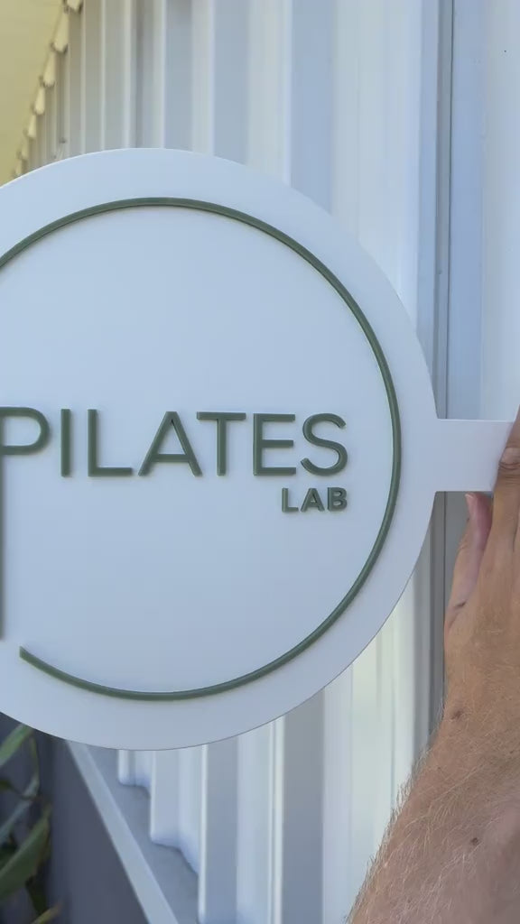 Minimalist Pilates Lab round hanging shopfront sign