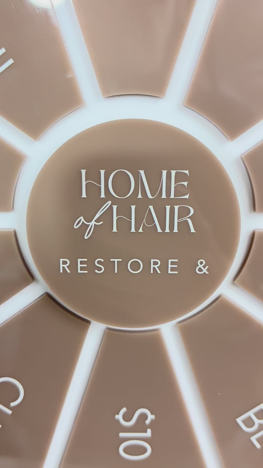 Close up video of brown spin the wheel with custom logo for salon giveaways