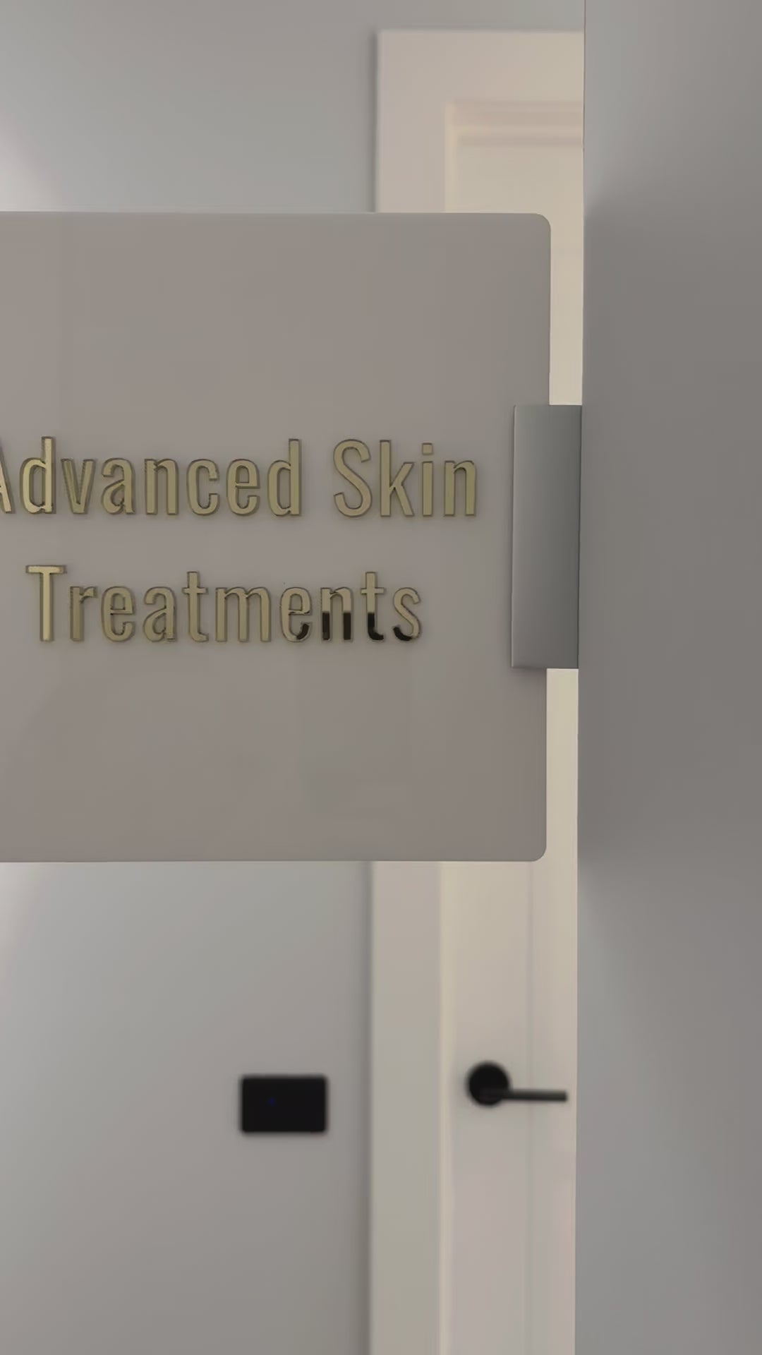 ceiling mounted corridor sign for advanced skin treatments clinic room