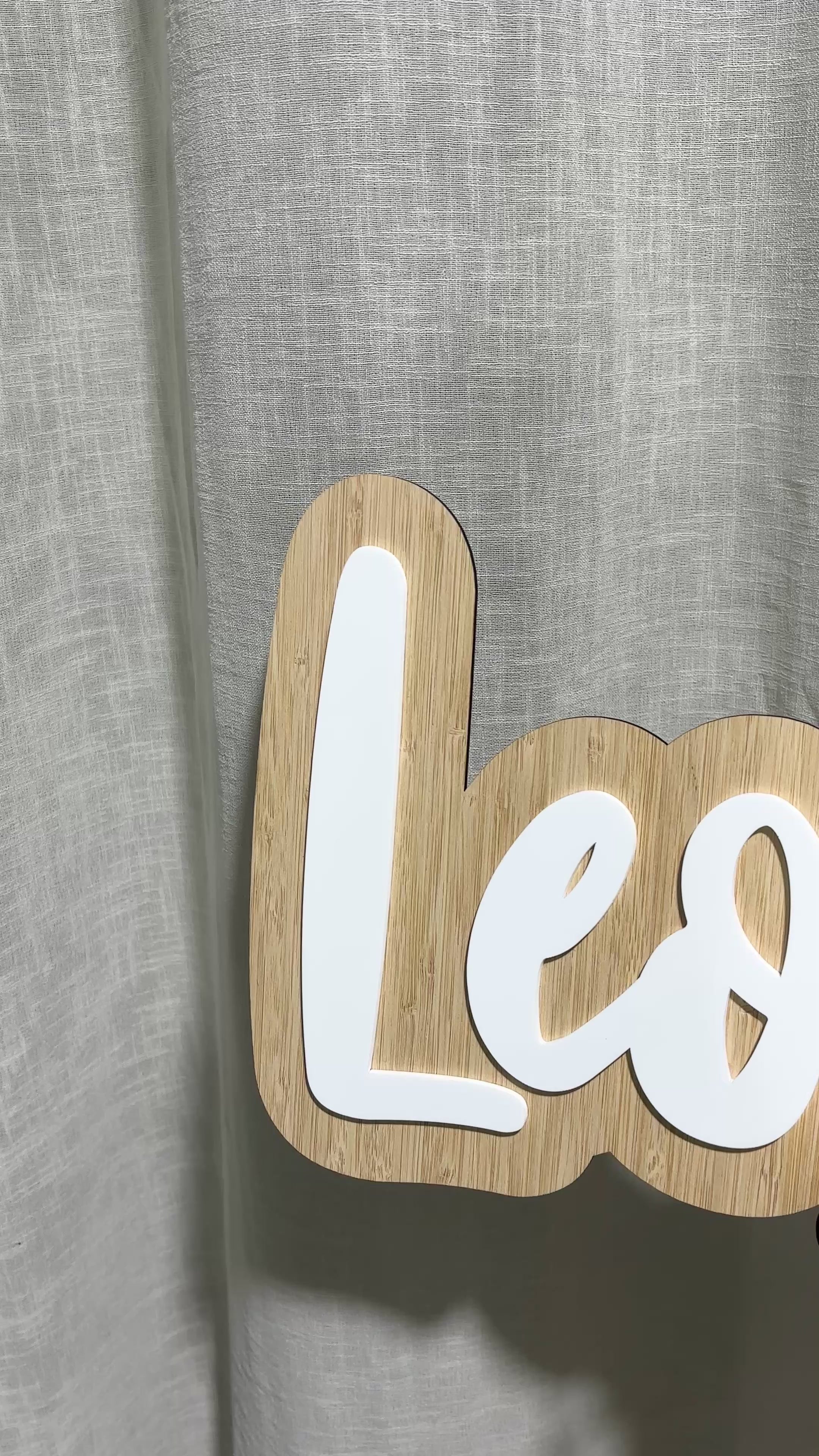 Close-up video of a custom bamboo name sign reading “Leonardo” in white 3D acrylic lettering, displayed on a black easel. Perfect for kids’ rooms, nurseries, or birthday decorations, showcasing modern personalised bamboo signage handmade in Australia.