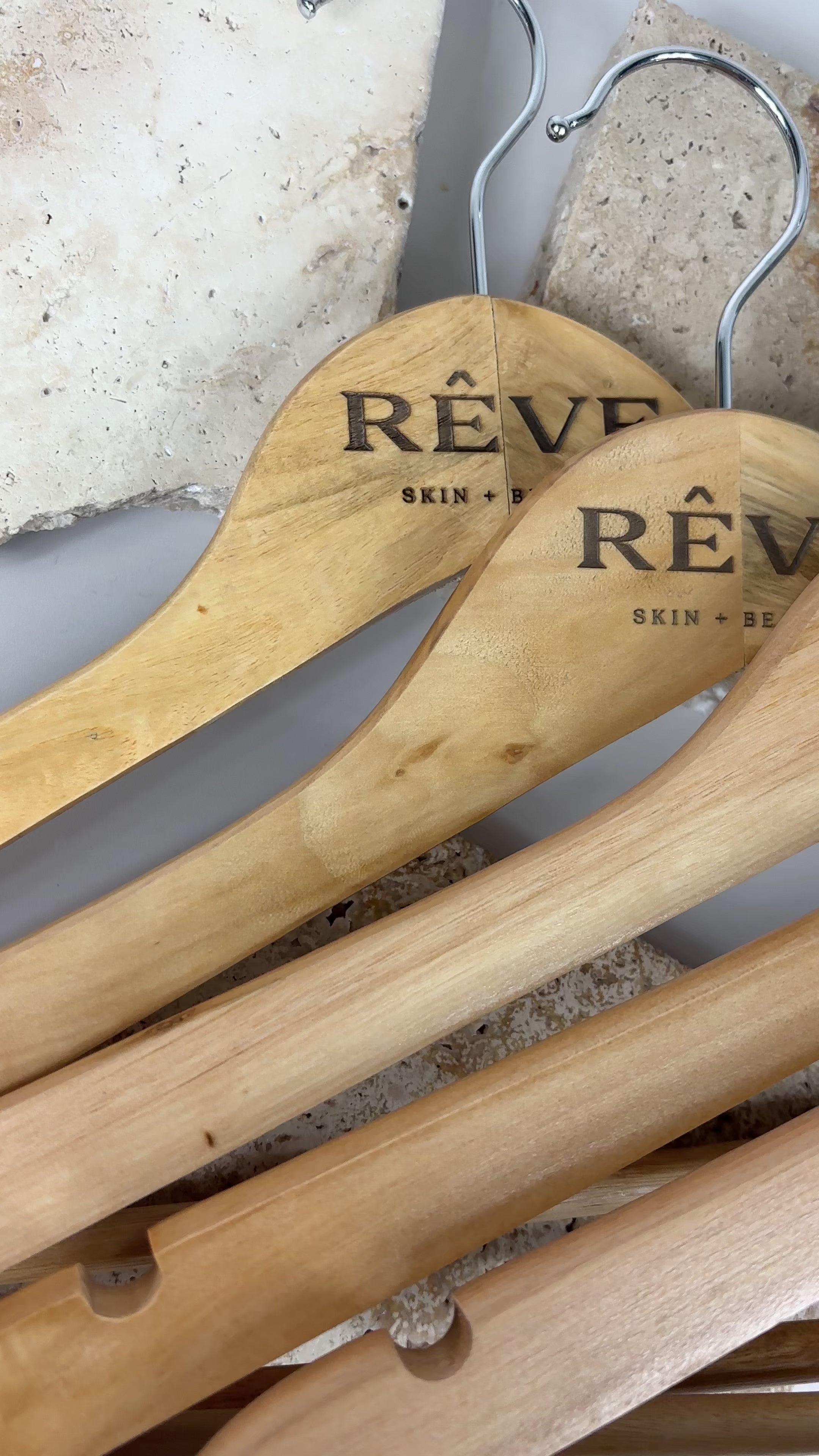 Custom engraved wooden coat hangers with RÊVE Skin + Beauty logo