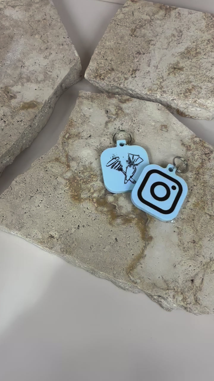 Custom video of NFC keychains on neutral stone background with social icons