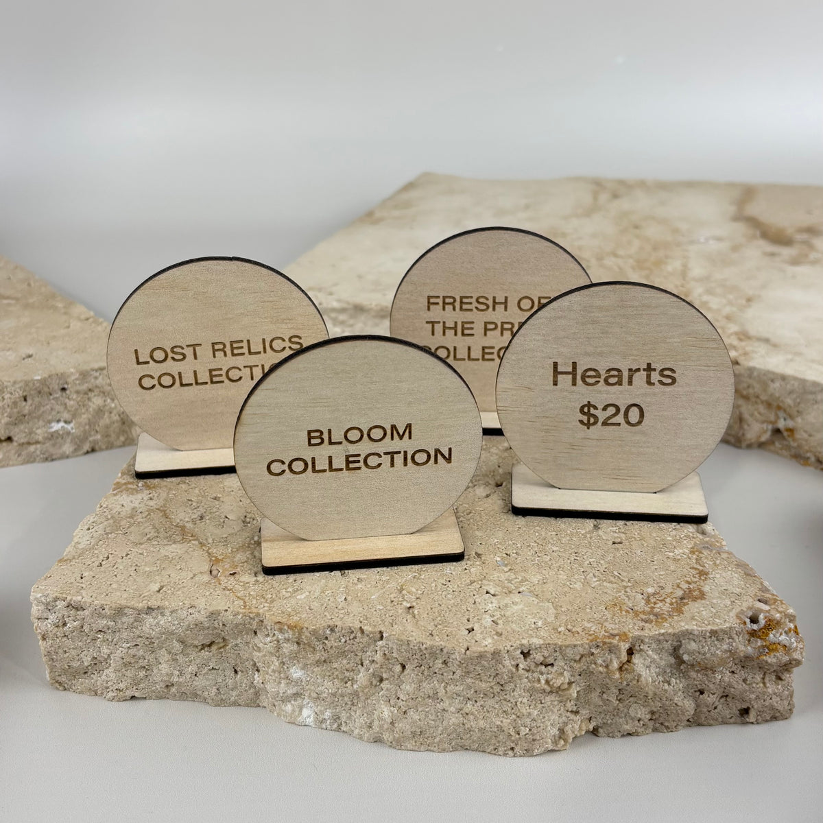 Small engraved timber display stands with round sign faces and matching bases, ideal for displaying product collections, pricing, promotions or information at market stalls, retail counters and shop displays.