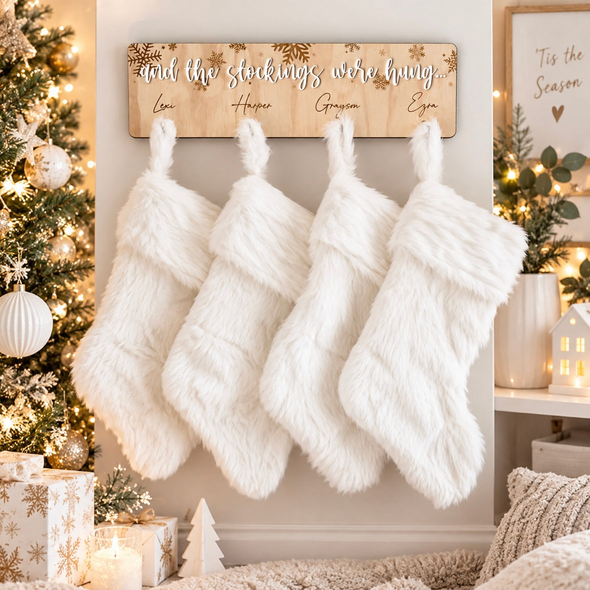 Personalised wooden Christmas stocking hanger with four family names and white stockings, displayed in a light modern Christmas setting with festive decorations.