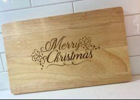 Personalised Christmas chopping board featuring engraved floral Merry Christmas design on wooden board