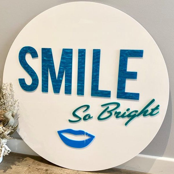custom white round acrylic sign with blue 3d text. smile so bright