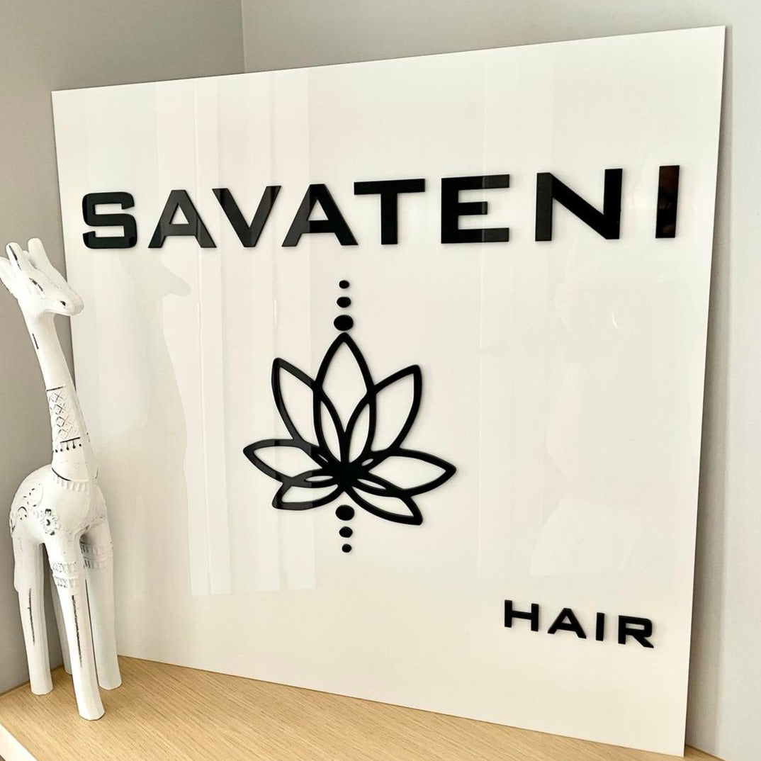 square white acrylic sign with black text. savateni hair