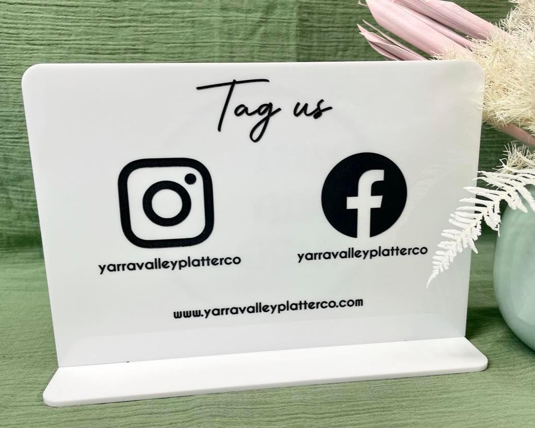 Social media display on custom acrylic stand with Instagram and Facebook handles – perfect for salons, cafes, and market stalls