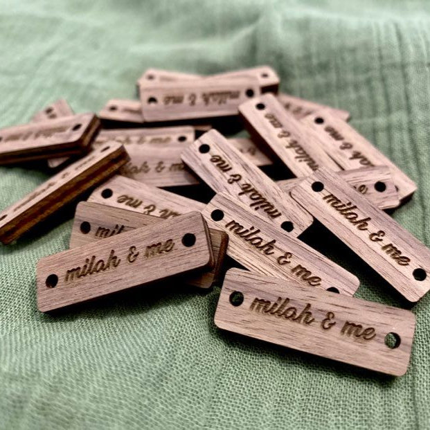 Pile of laser cut acrylic rectangle tags engraved with small business names