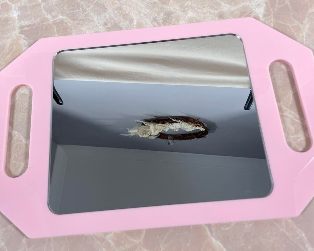 Close up of pink branded mirror surface showing reflection