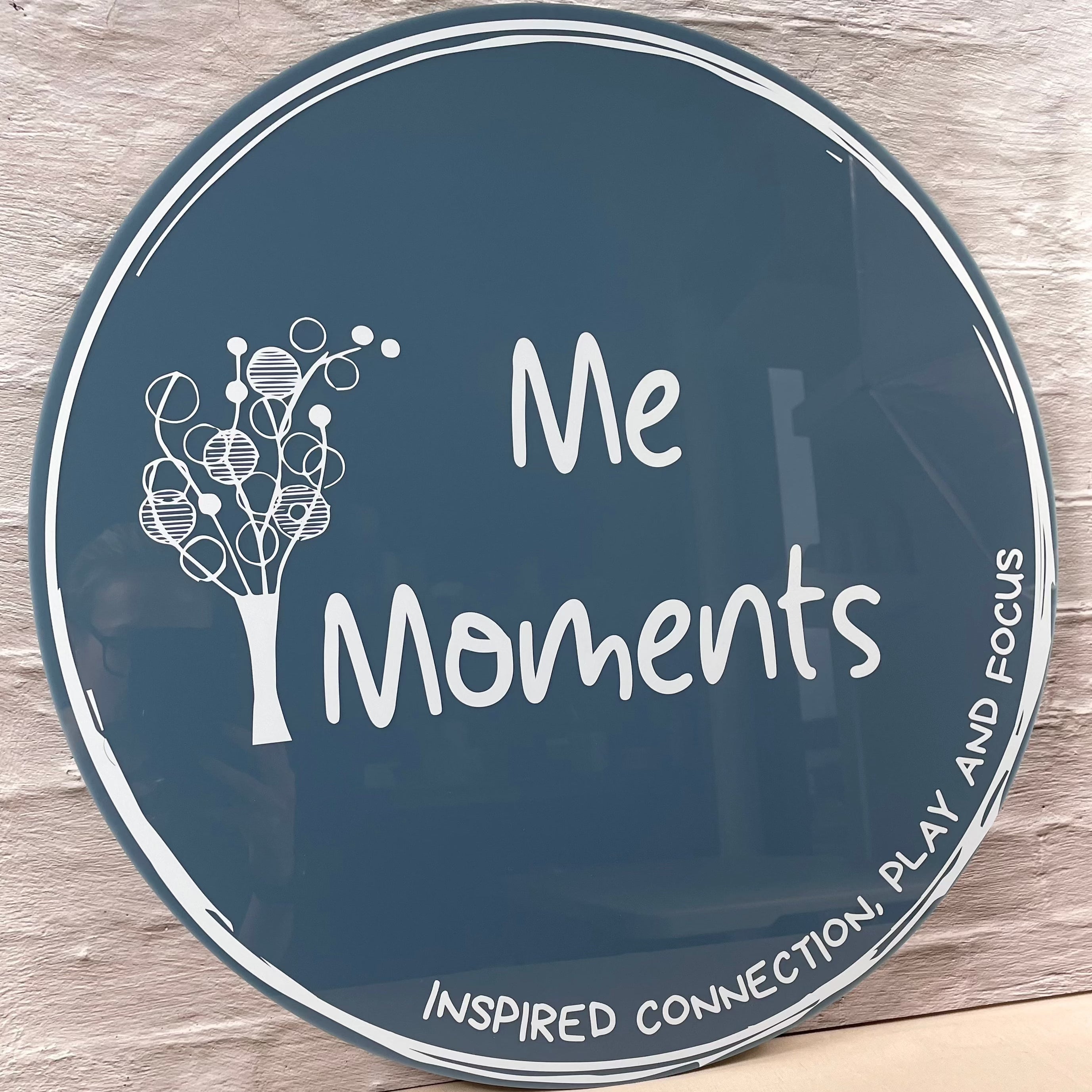 Round navy and white UV sign for Me Moments