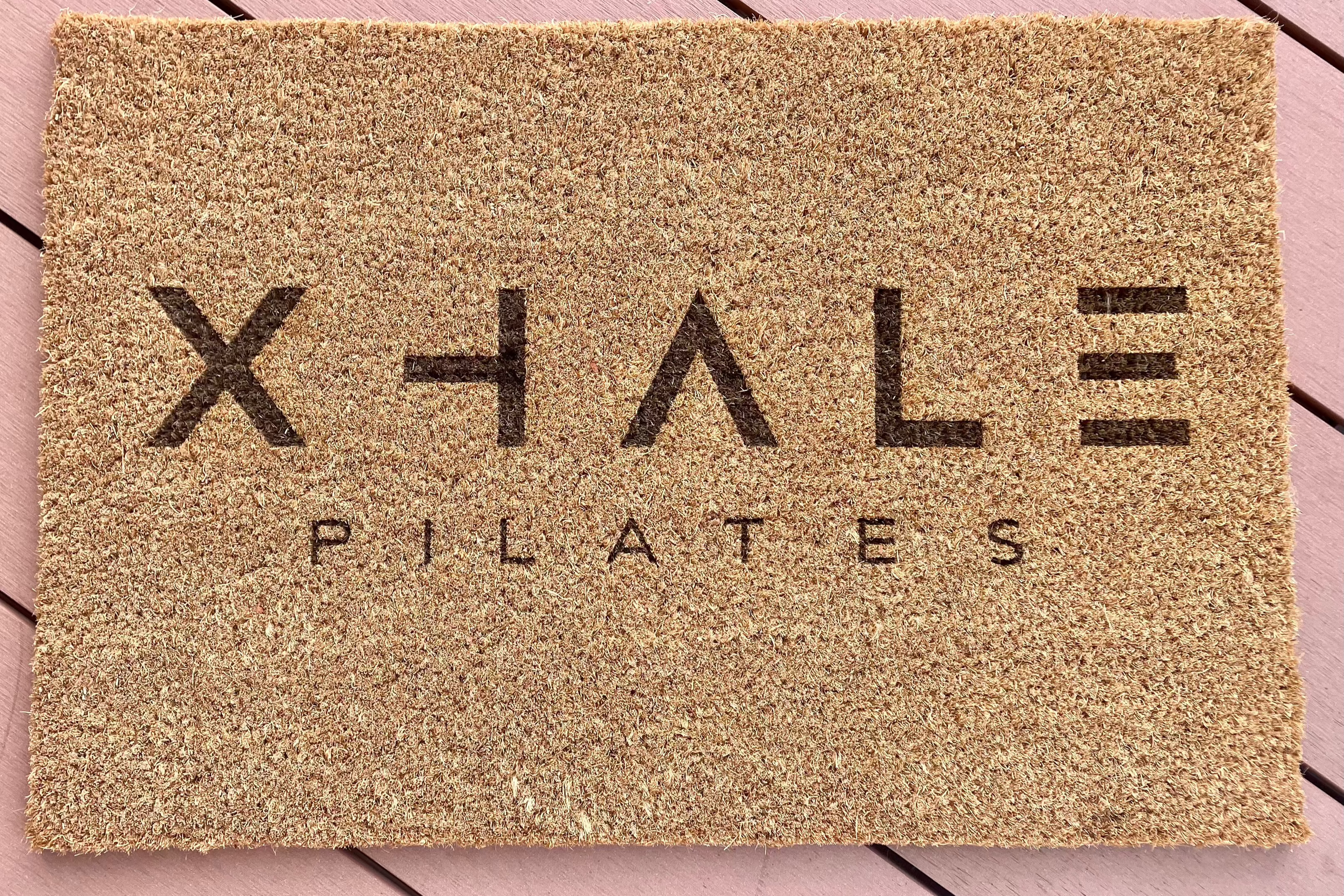 Pilates studio logo on a branded entrance mat