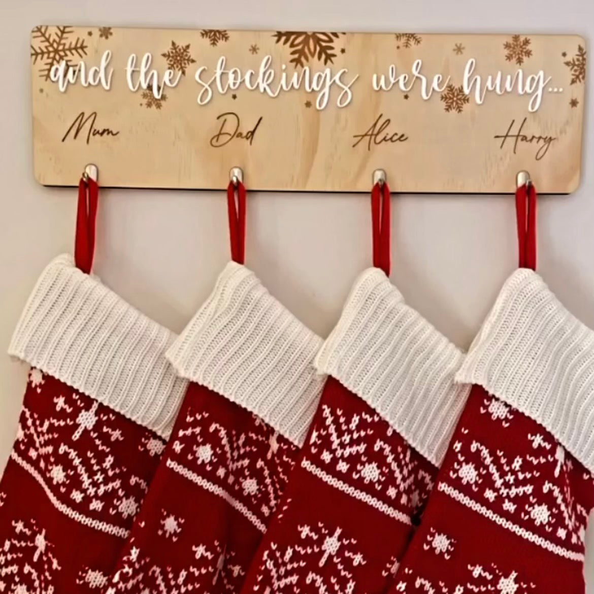 Festive stocking hanger with red hooks for displaying personalised family Christmas stockings