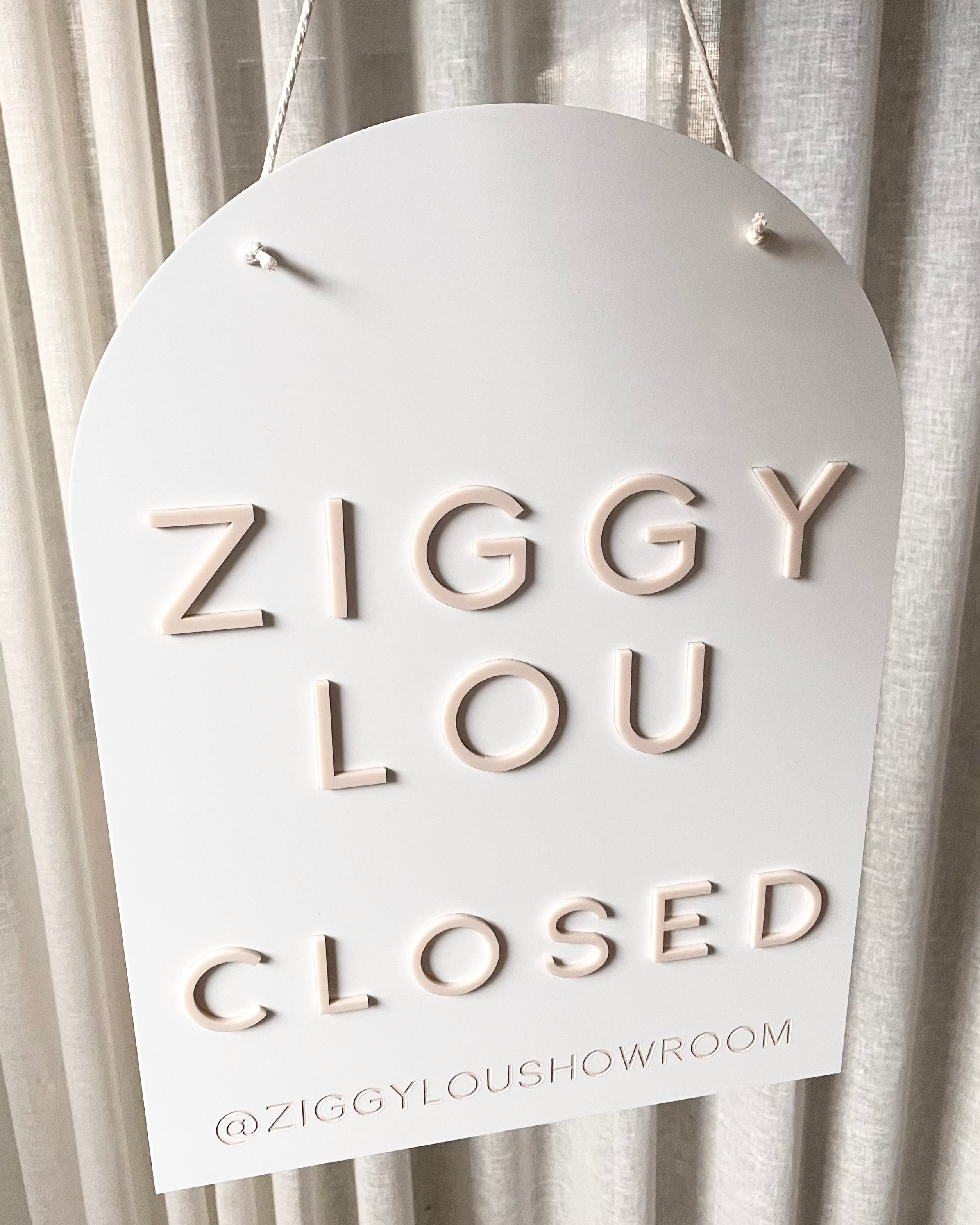 Custom arched closed sign for Ziggy Lou boutique in white acrylic