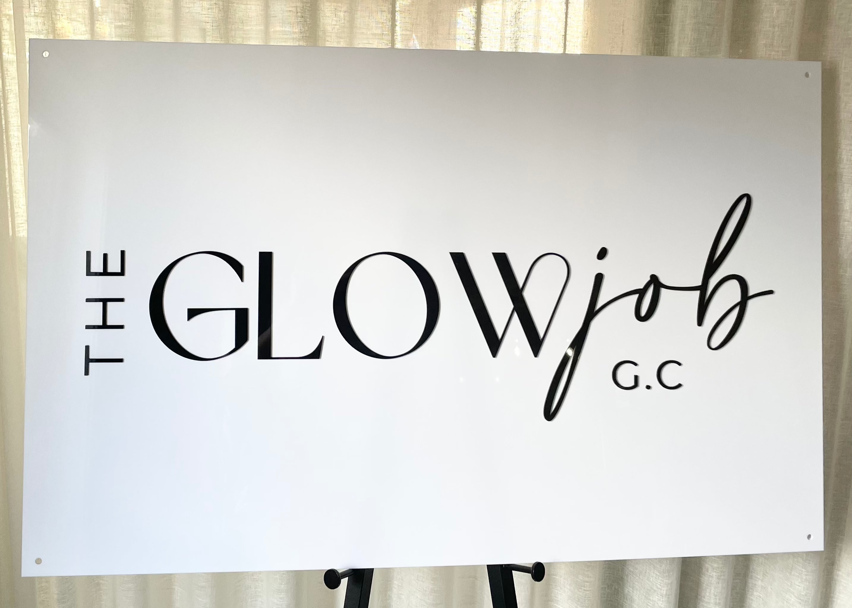 Bold black and white acrylic signage for the Glow Job G.C.