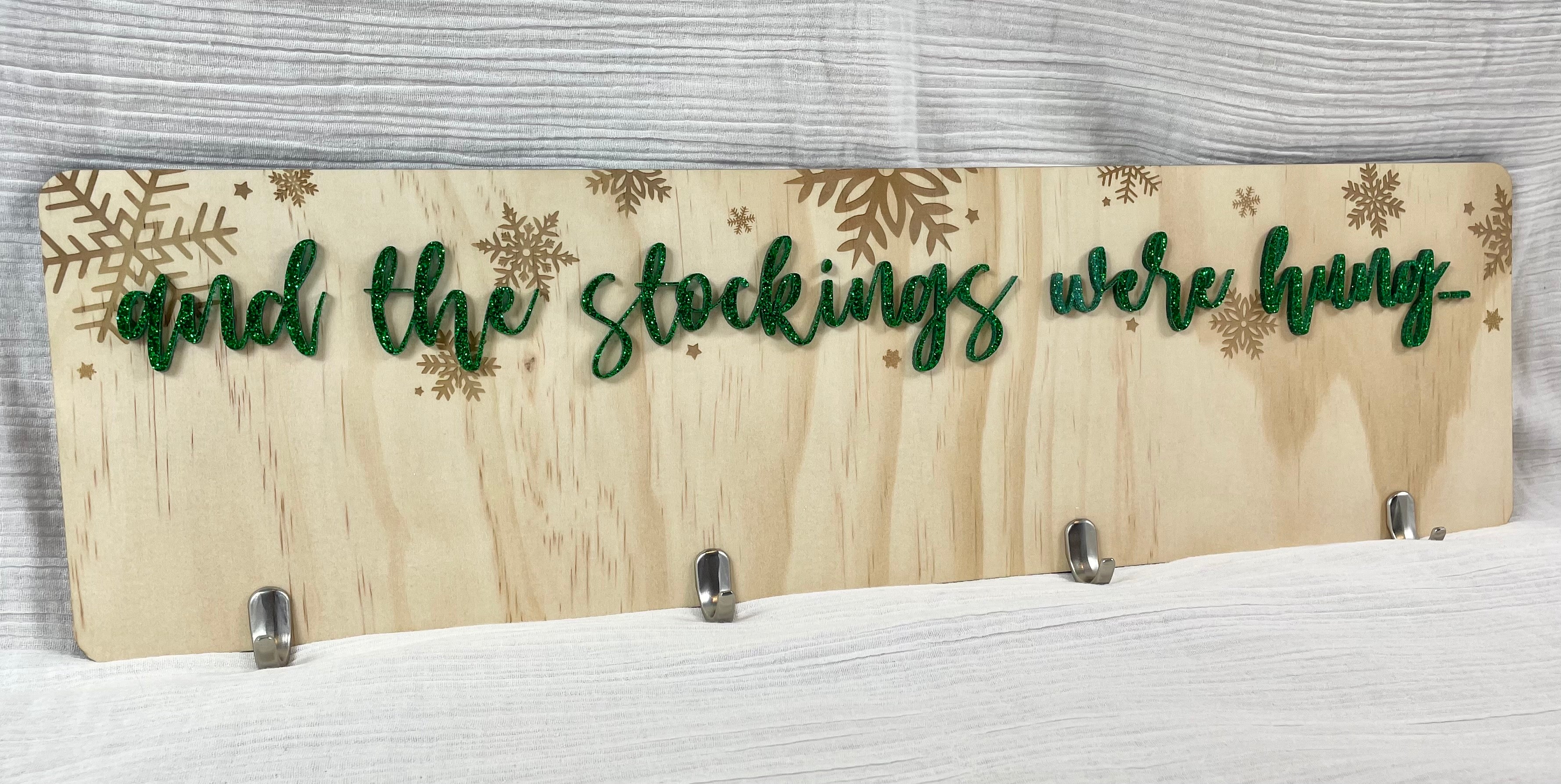 Custom wooden stocking hanger with personalised name hooks and Christmas-themed design