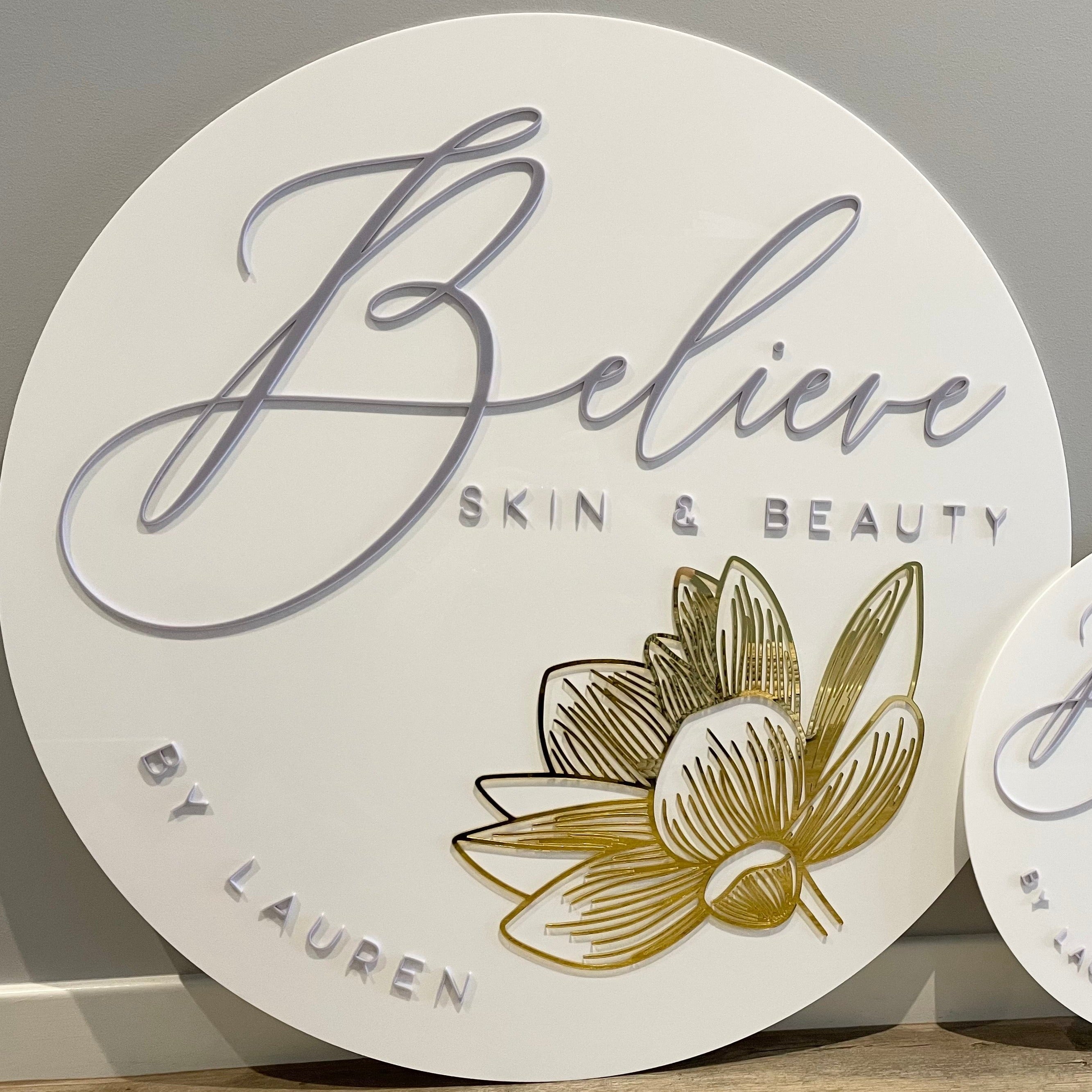 modern white and gold round sign. believe skin & beauty