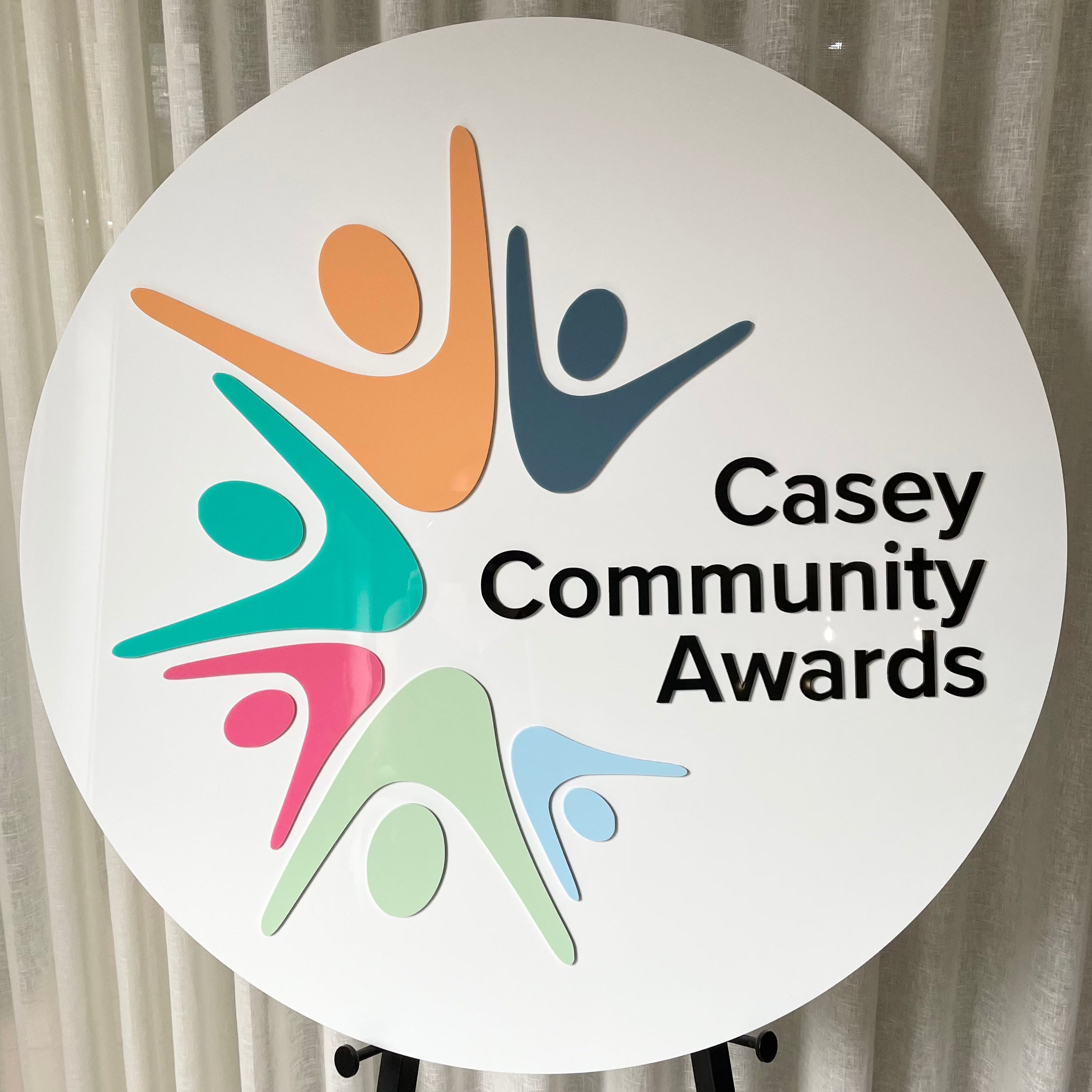 colourful awards logo on white round acrylic sign. casey community awards