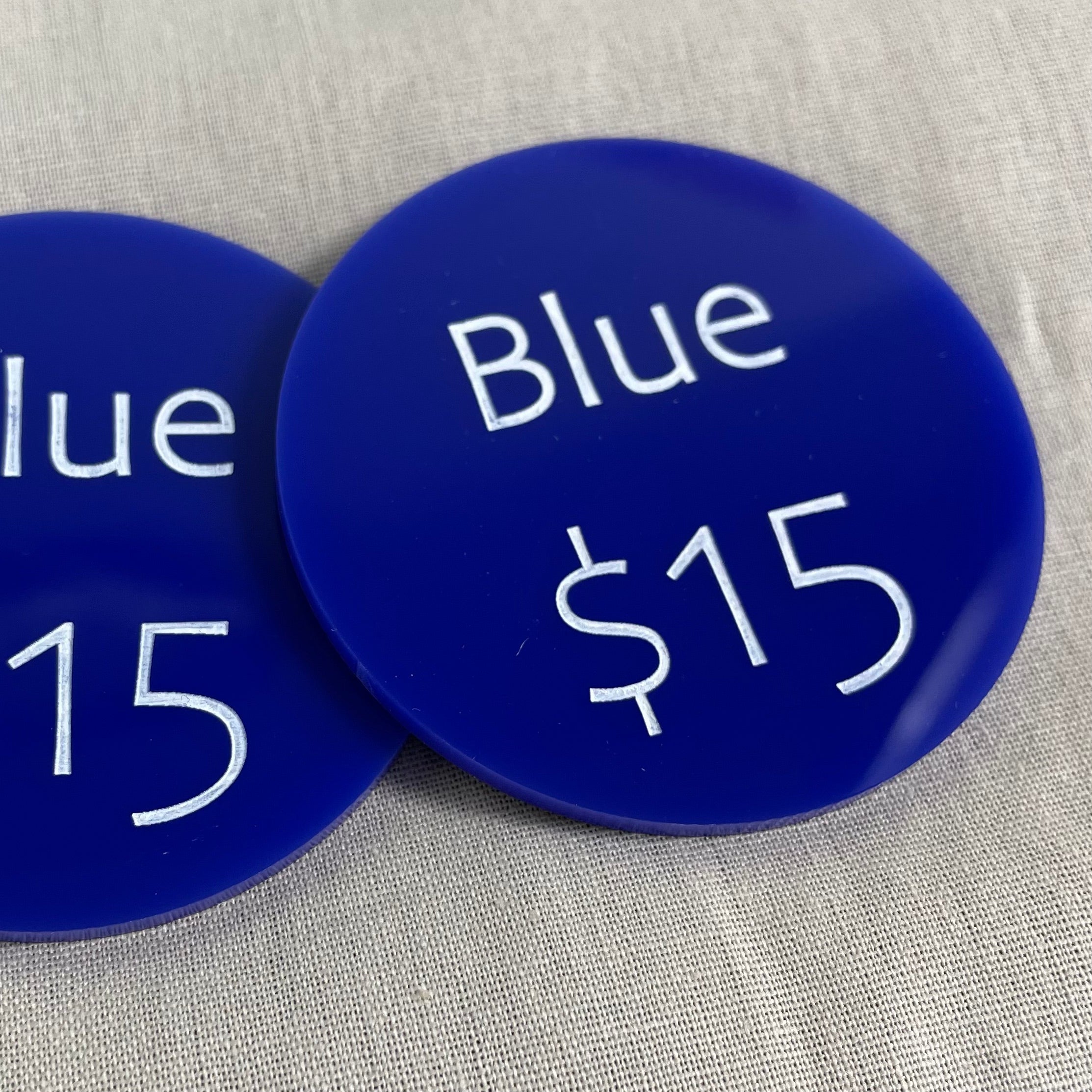 Blue acrylic price discs showing $15 for handmade items
