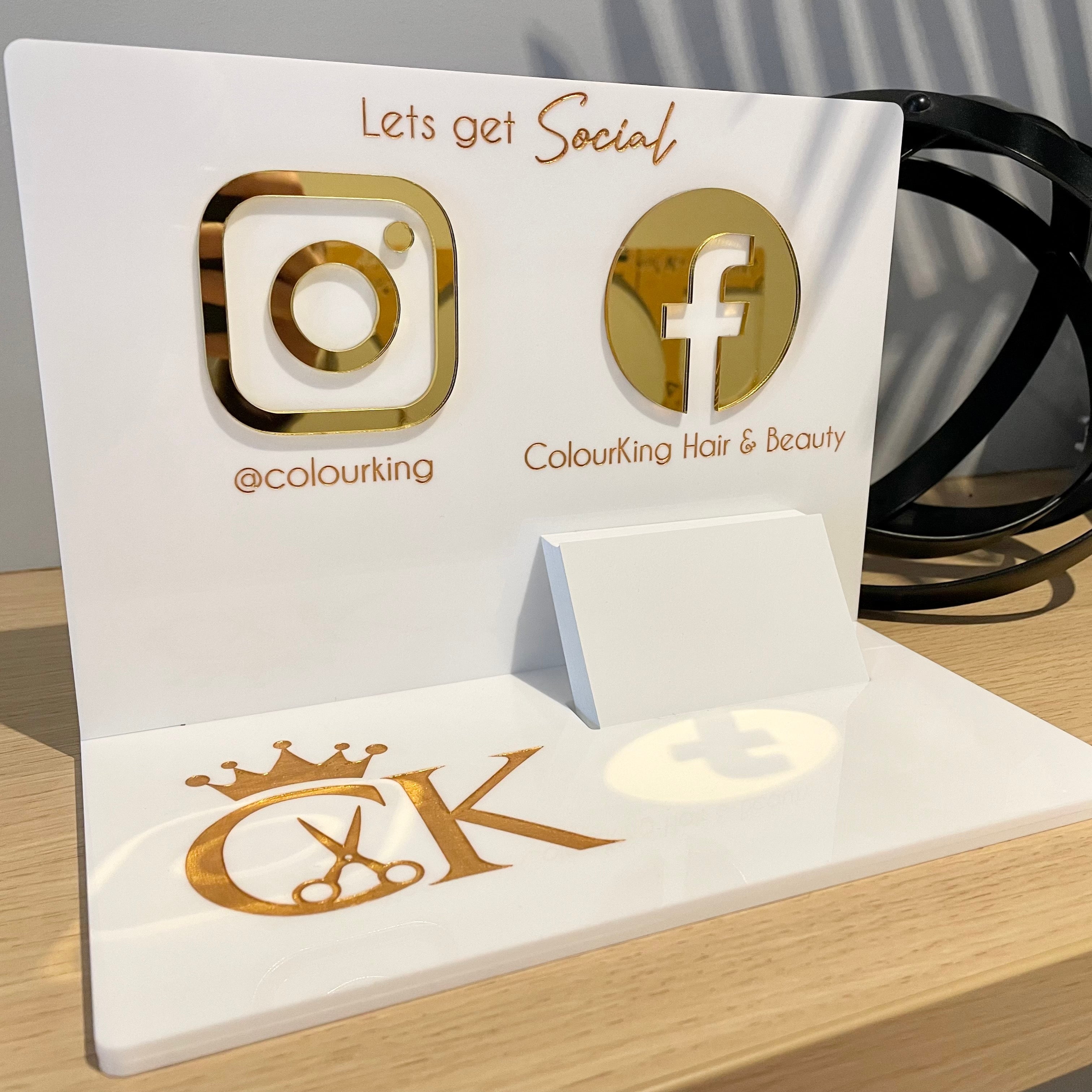 Branded white and gold acrylic display with social icons for hospitality counter