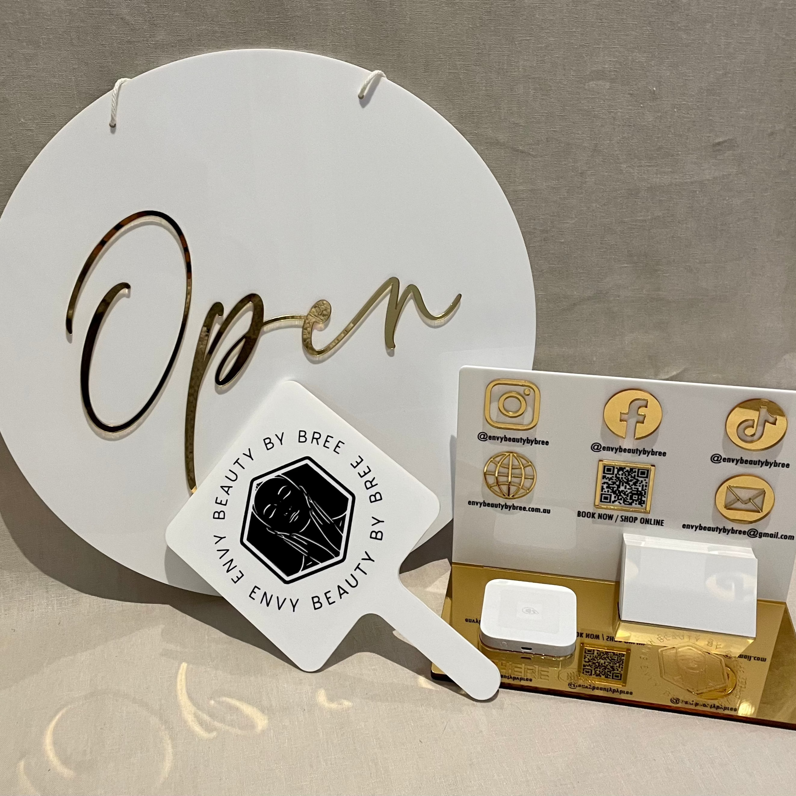 Round acrylic ‘Open’ sign with white background and branding accessories