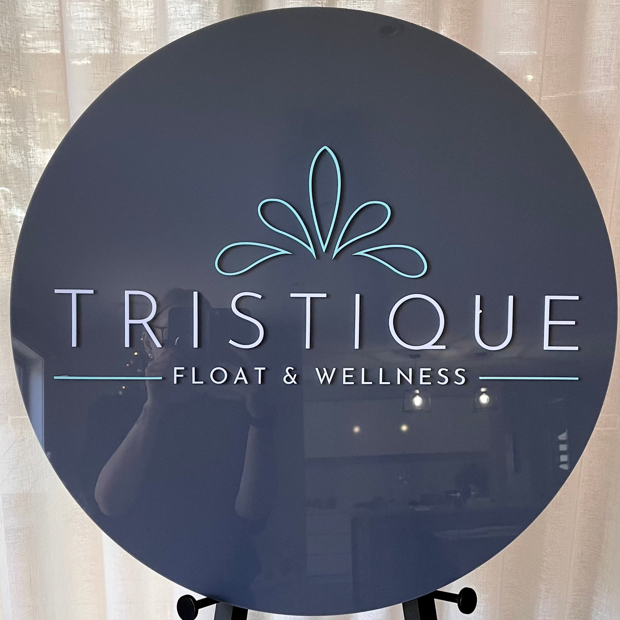 dark charcoal acrylic sign with wellness brand. tristeque float & wellness