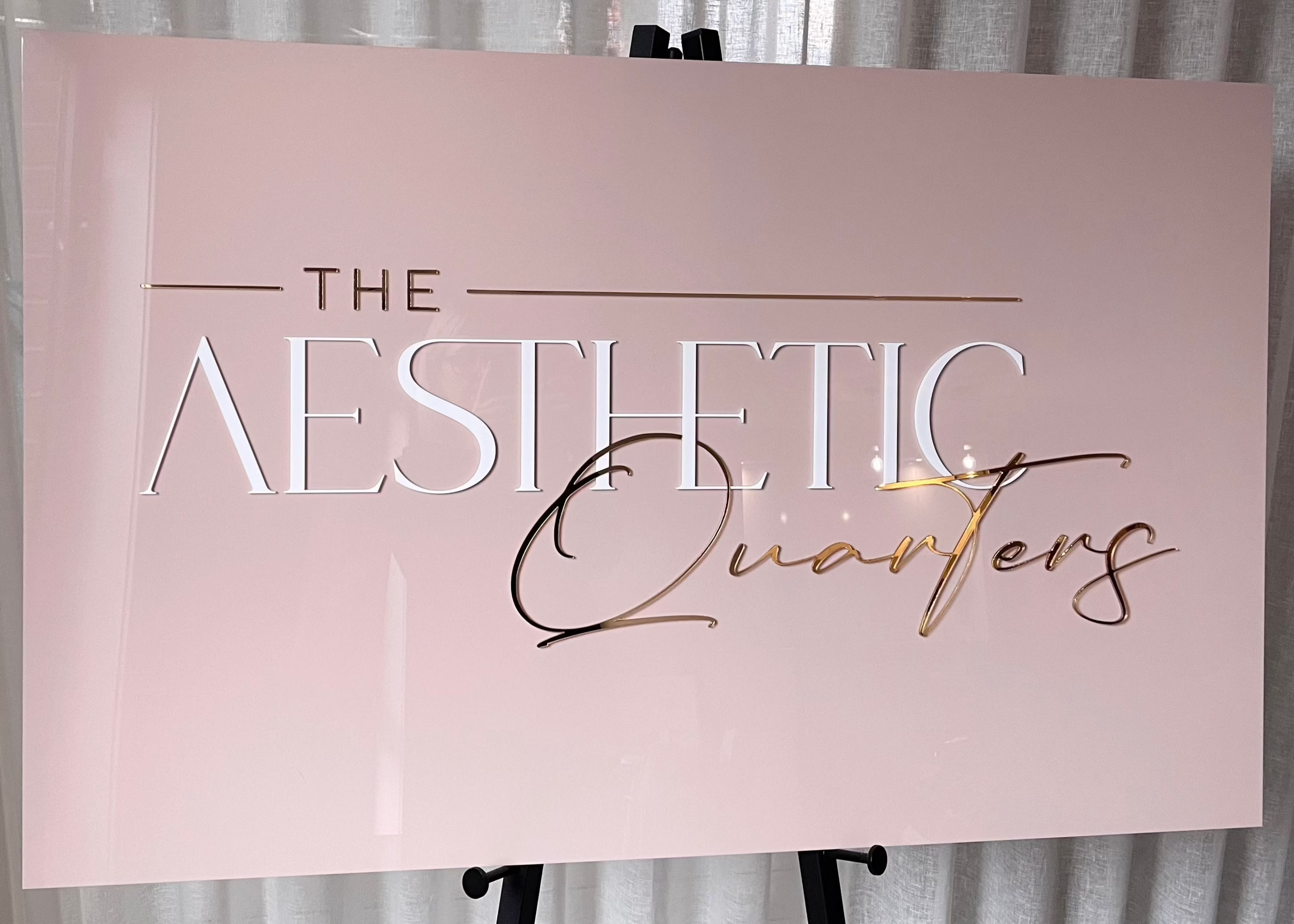 Pink and gold business sign for The Aesthetic Quarters