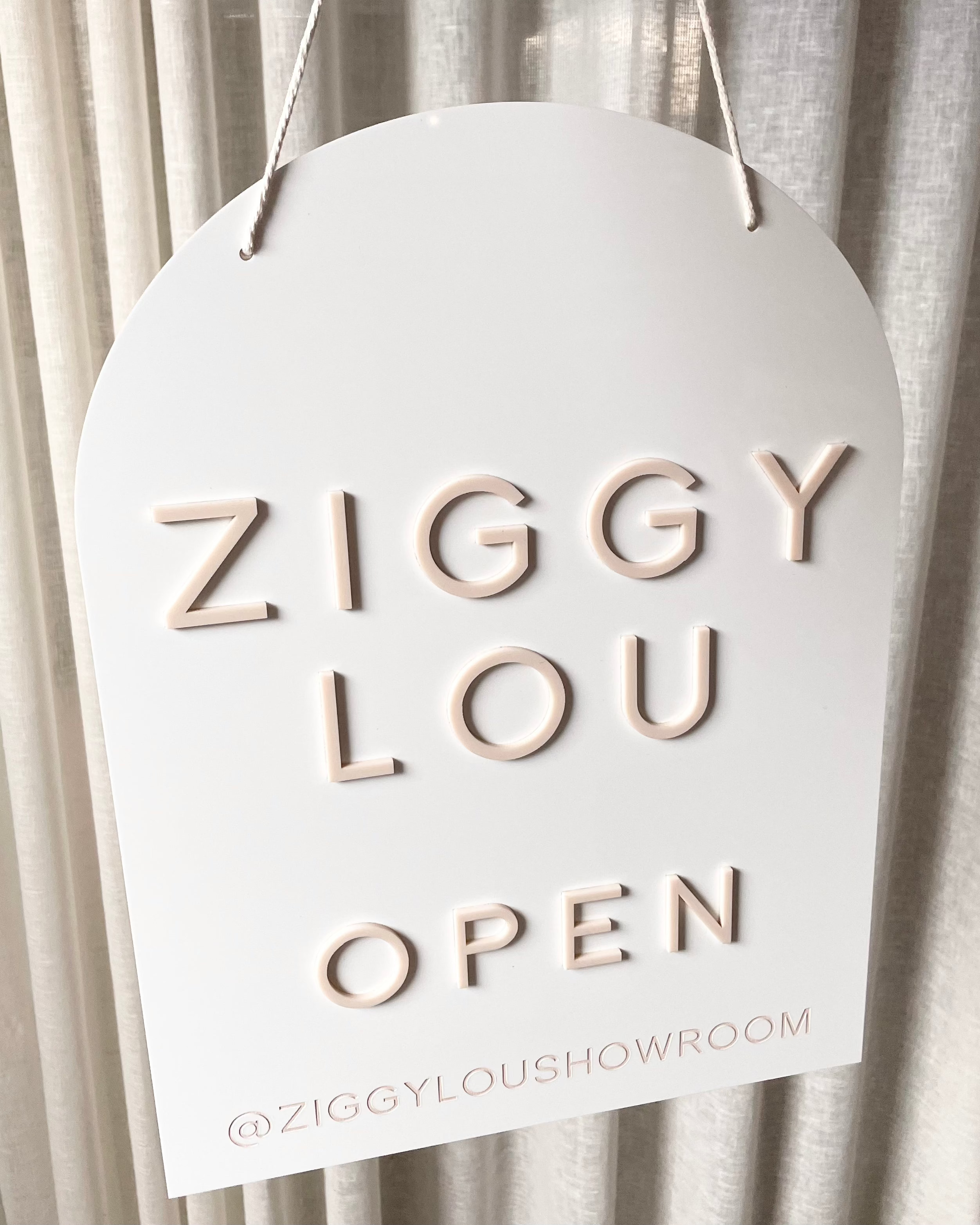 Custom arched open sign for Ziggy Lou boutique in white acrylic