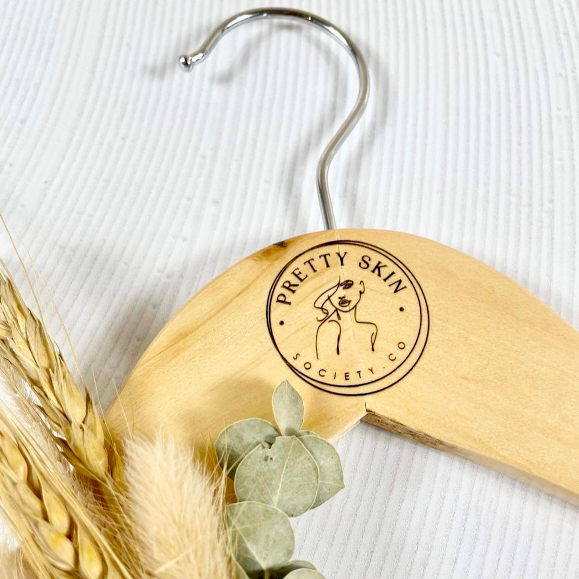 Close up of engraved coat hanger showing beauty clinic branding