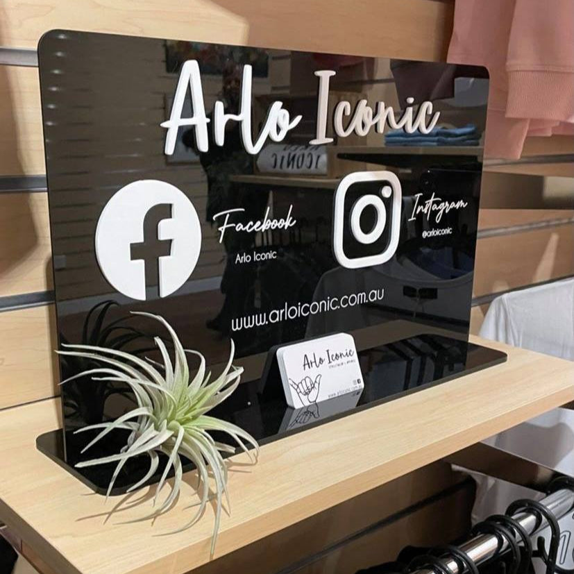 Custom social media display stand with logo, Facebook and Instagram icons on shop counter