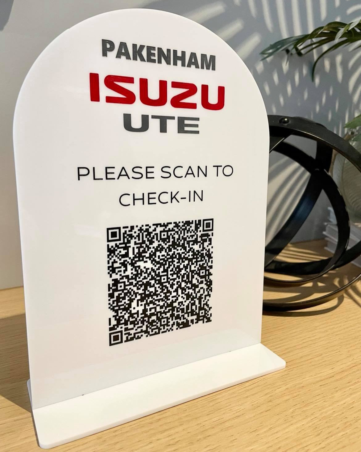 White scan to check-in sign for Isuzu dealership front desk