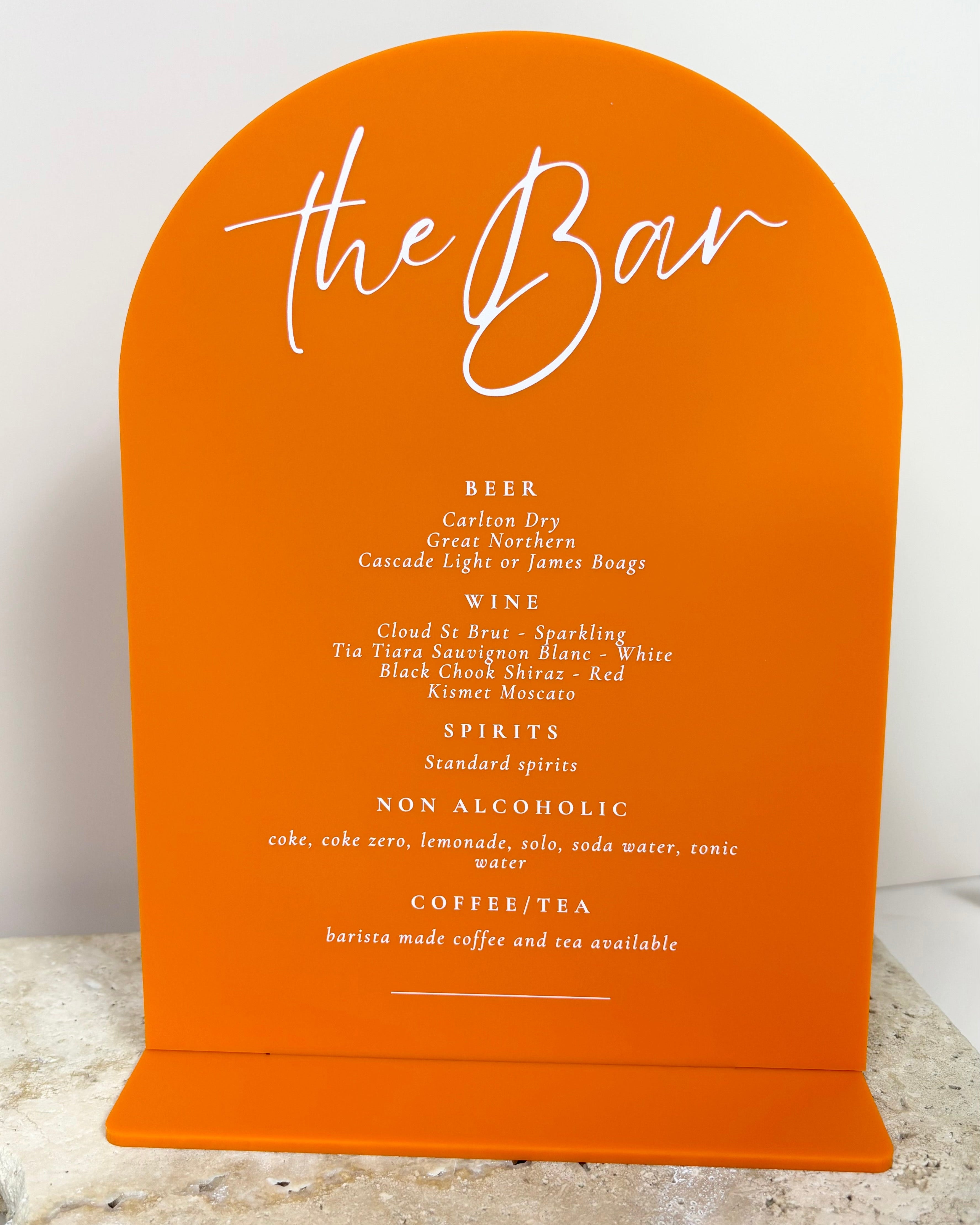 Bold orange acrylic bar menu with cocktail list and white engraved text
