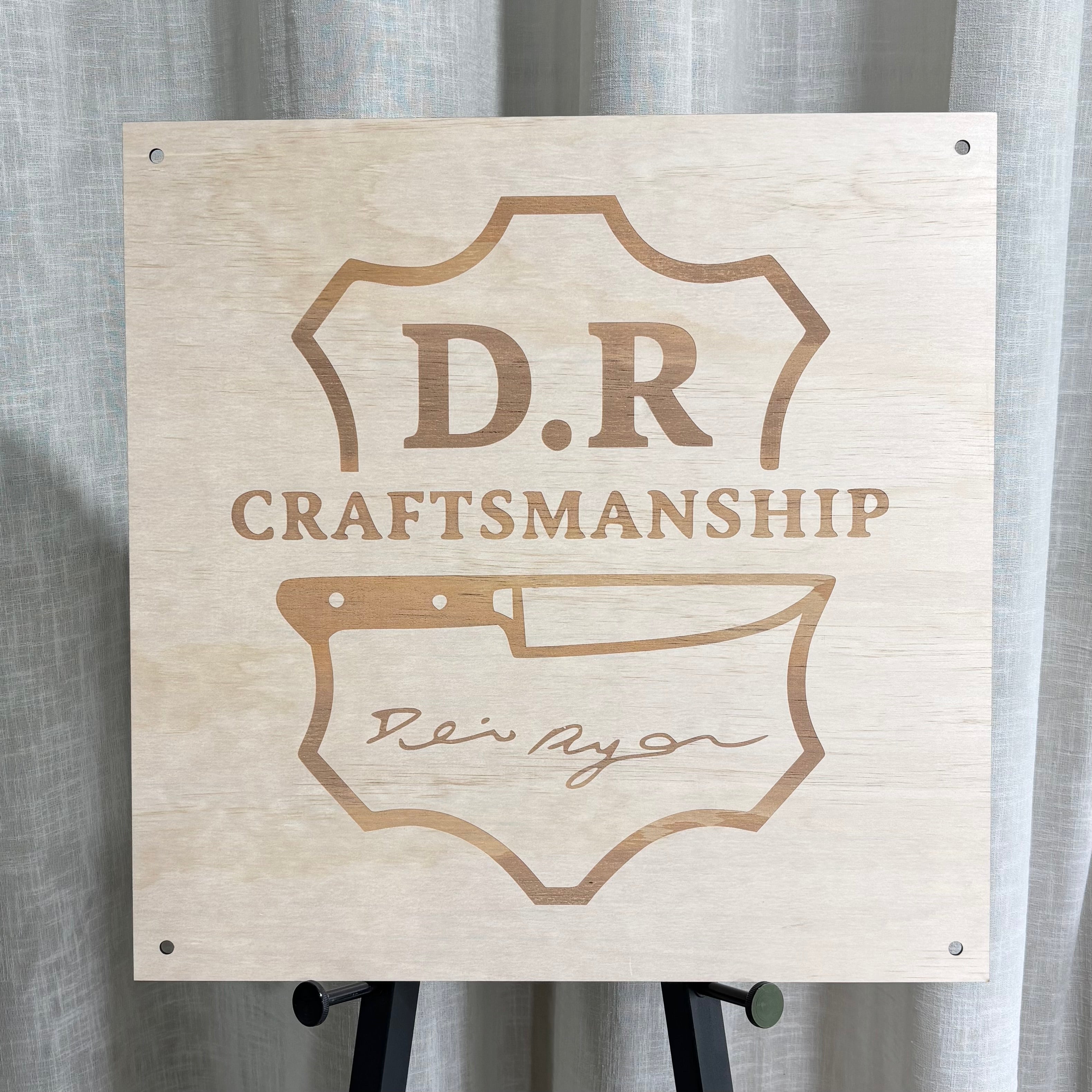 Custom engraved timber business sign featuring “D.R Craftsmanship” logo with precision laser engraving on natural plywood, mounted with black standoffs – premium Australian made wall signage for trades, workshops and small businesses.