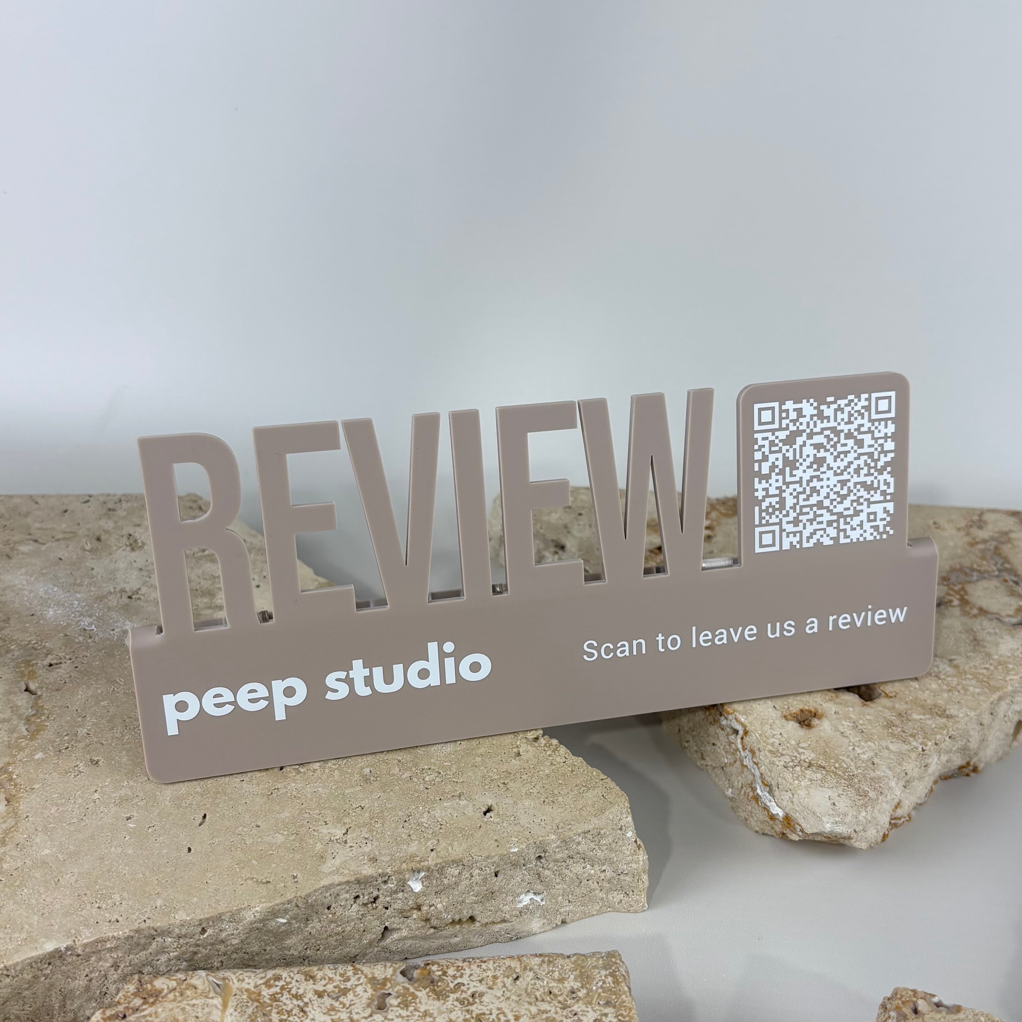 Custom acrylic Google review stand with integrated QR code for salons, beauty studios and small businesses. Modern countertop review display featuring cut-out “REVIEW” lettering, QR code scanning technology and customer feedback signage designed to increase Google reviews, online reputation and business visibility.