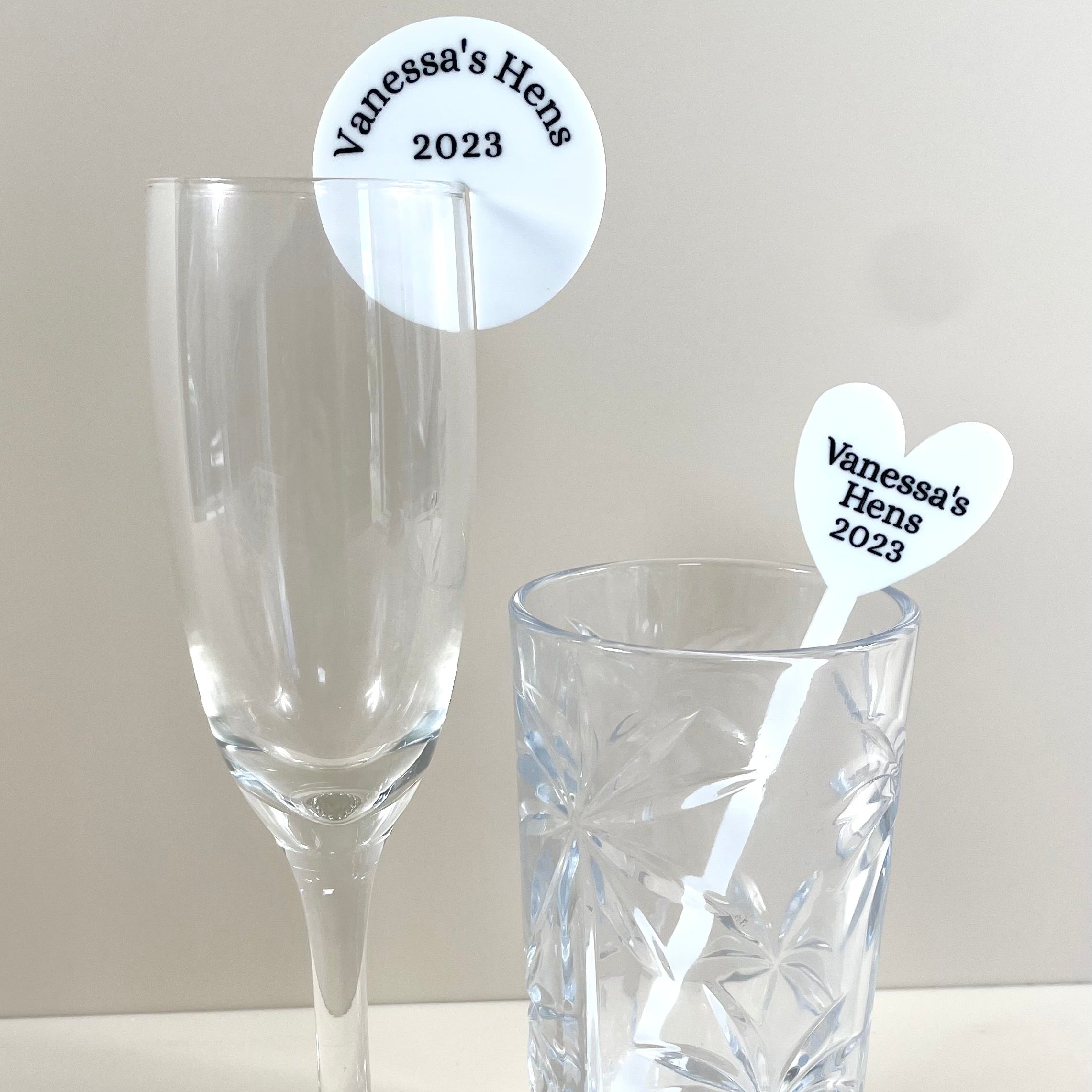 Heart shaped hens drink tags on champagne and water glasses