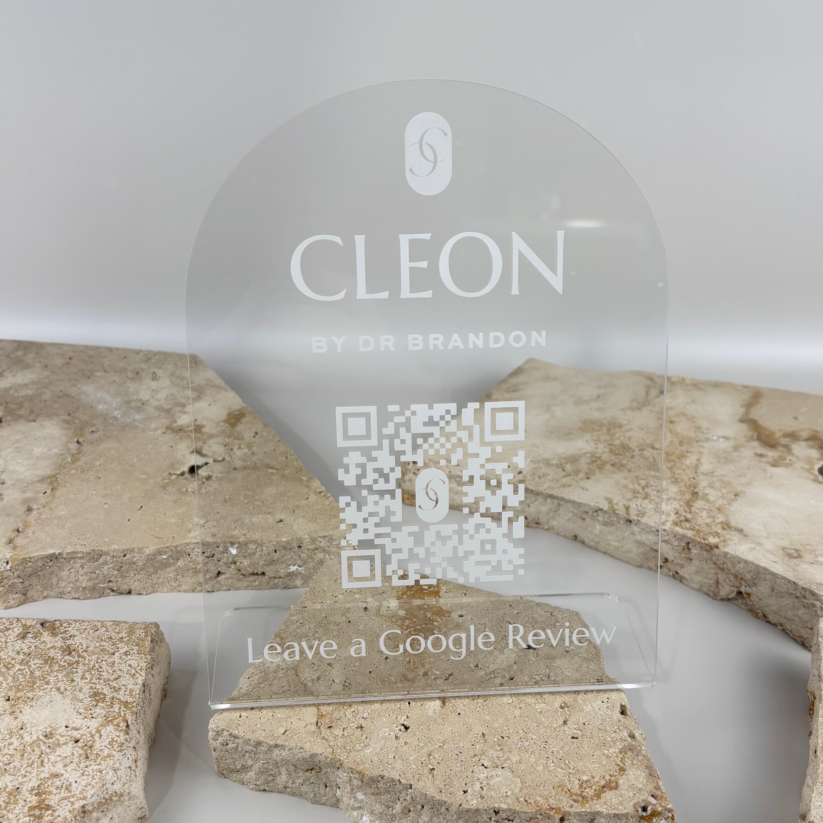 Clear acrylic Google review stand with frosted white UV printed logo, QR code and review request, designed as a premium countertop sign for medical, cosmetic and professional businesses.