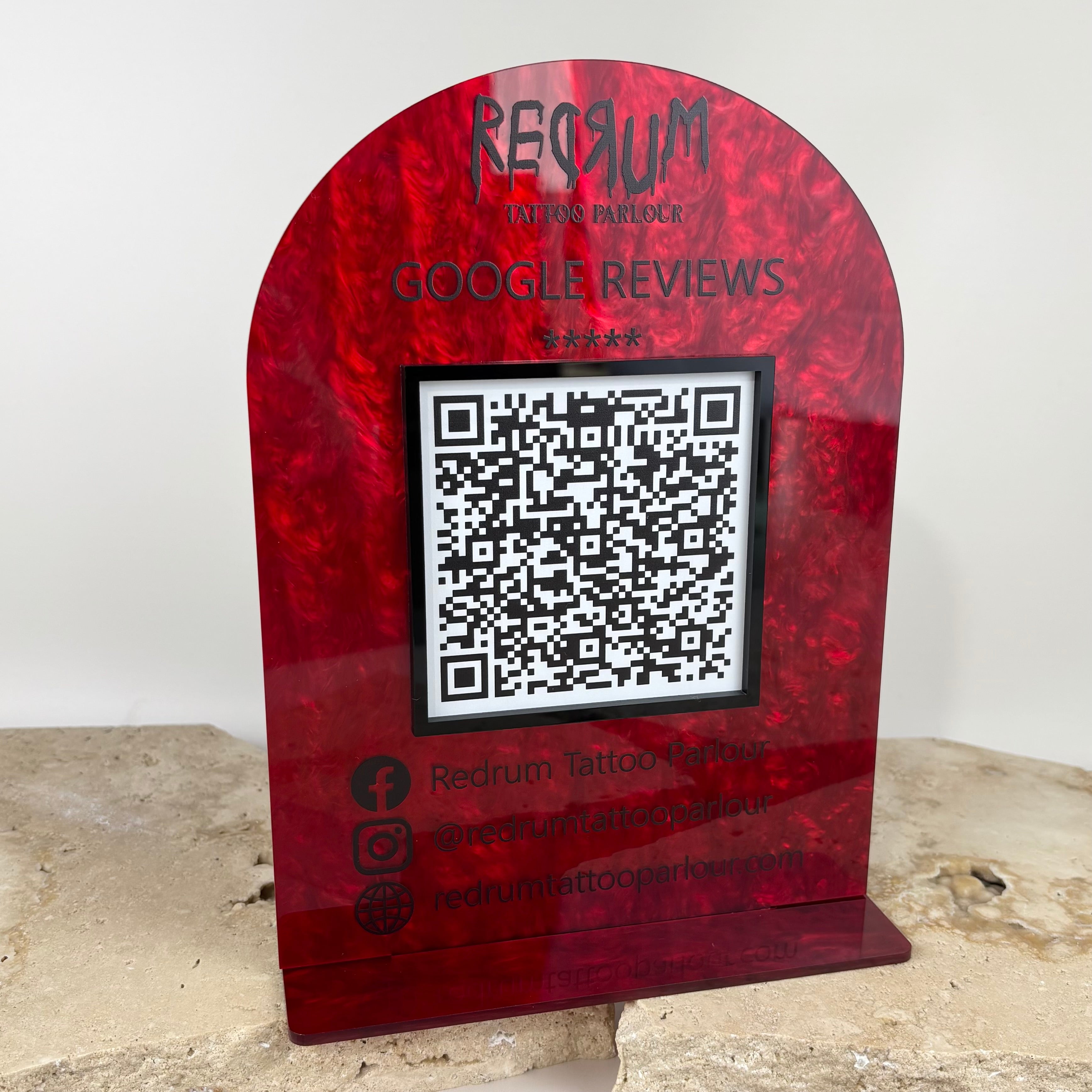 Custom red acrylic Google review stand with built in QR code, premium arched countertop sign for salons, tattoo studios and small businesses to boost five star reviews, Australian made branded display with social media details.