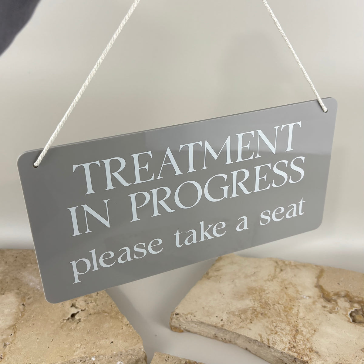 Custom grey acrylic treatment in progress hanging door sign with white lettering and rope, designed for beauty salons, clinics and appointment-based businesses.