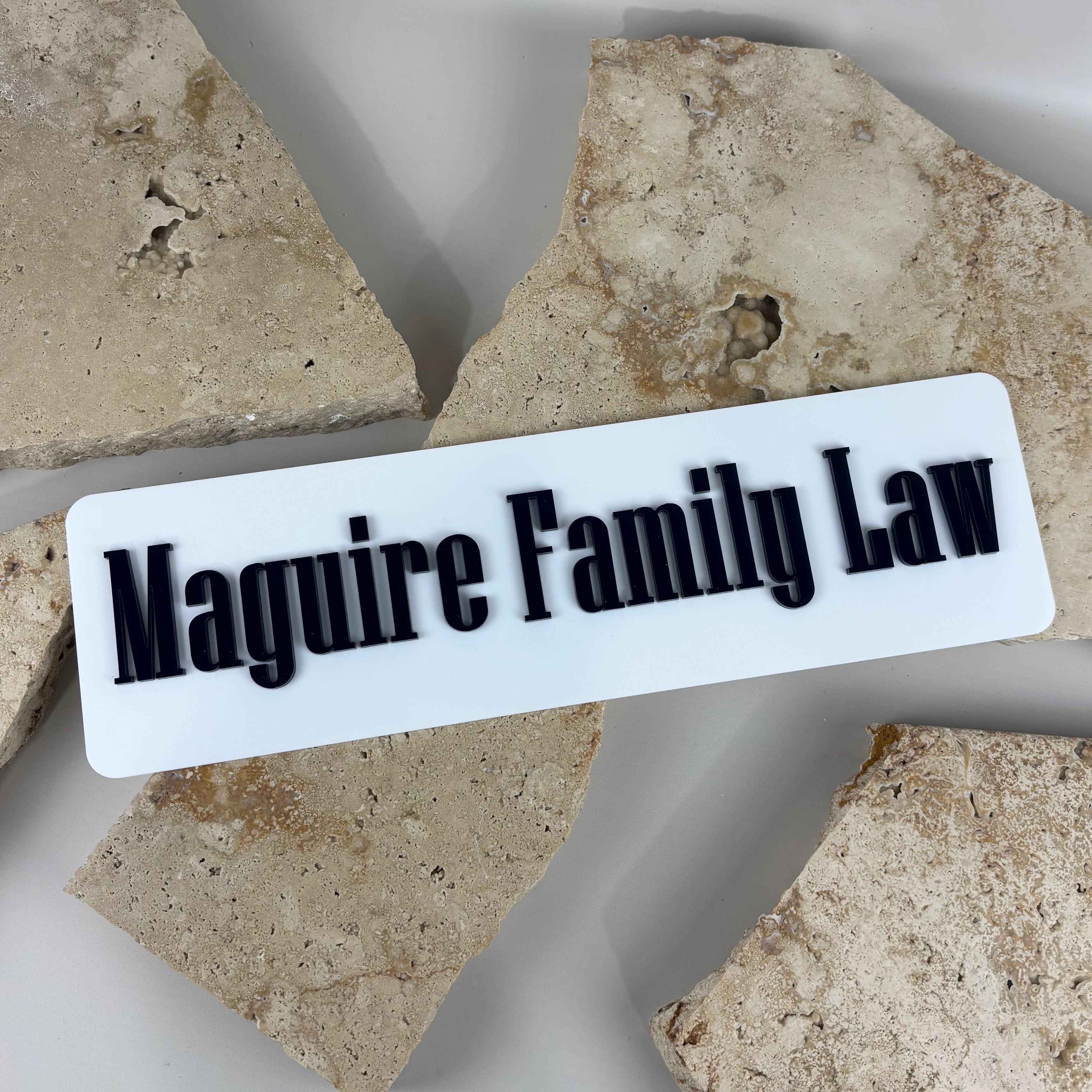 Custom acrylic business sign with raised 3D lettering, rectangular name signage for law firm branding, modern office wall sign with bold black acrylic text on white backing