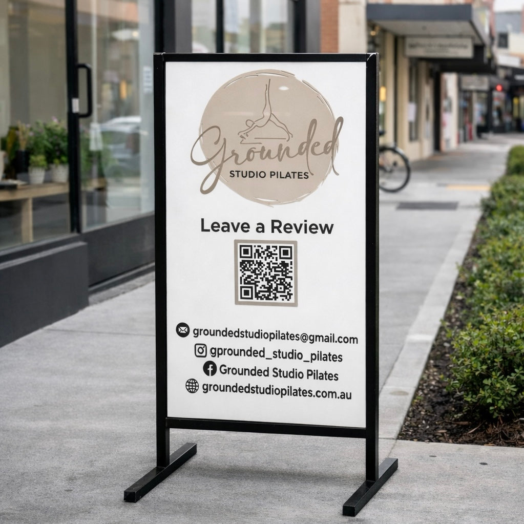 T frame sidewalk sign outside a Pilates studio featuring a custom branded acrylic insert with QR code, ideal for business advertising, reviews and footpath signage in Australia