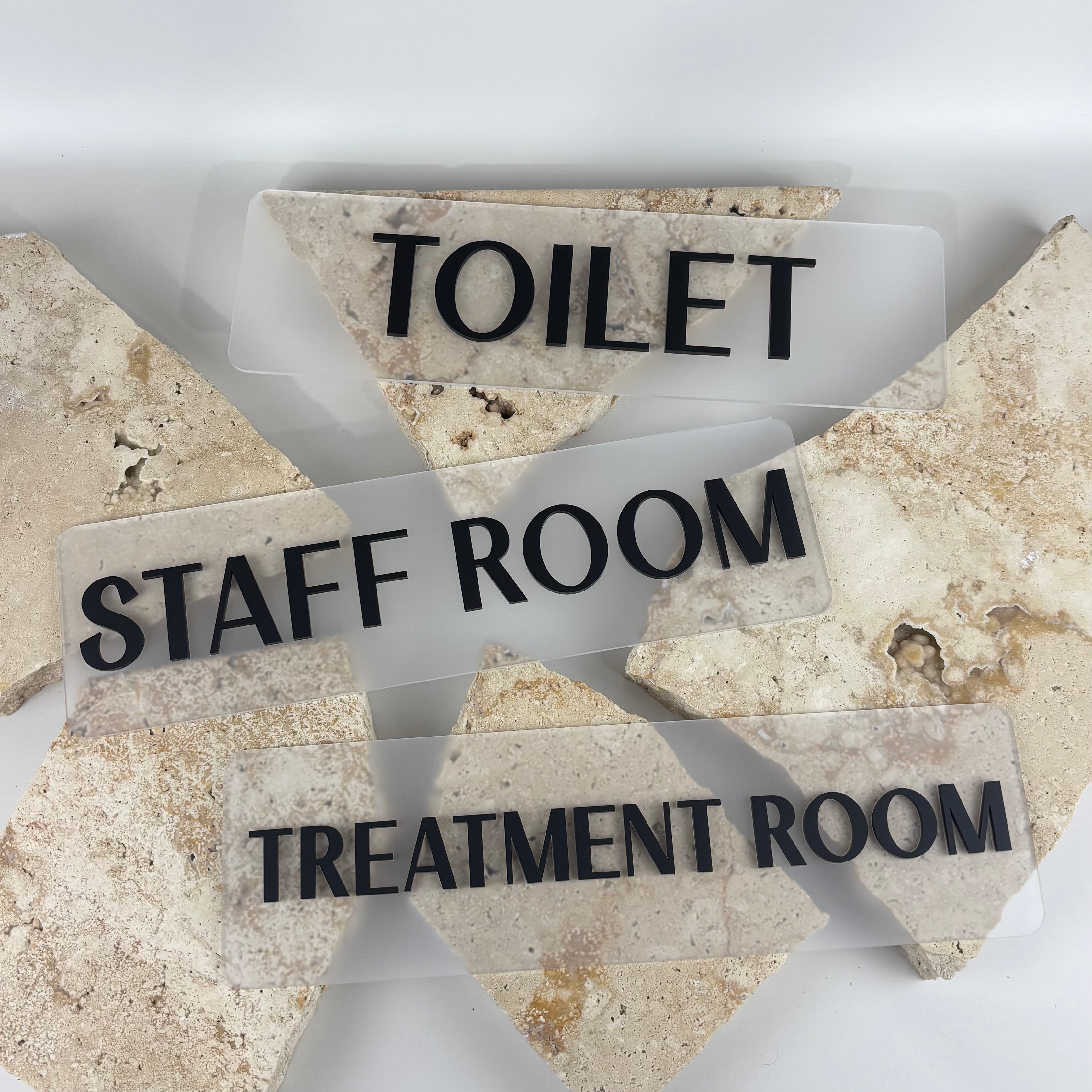 Custom frosted acrylic room signs with raised black 3D lettering for toilets, staff rooms and treatment rooms. Modern office, salon and clinic door signage with minimalist design, perfect for businesses, medical clinics, beauty salons, dental practices and commercial spaces.