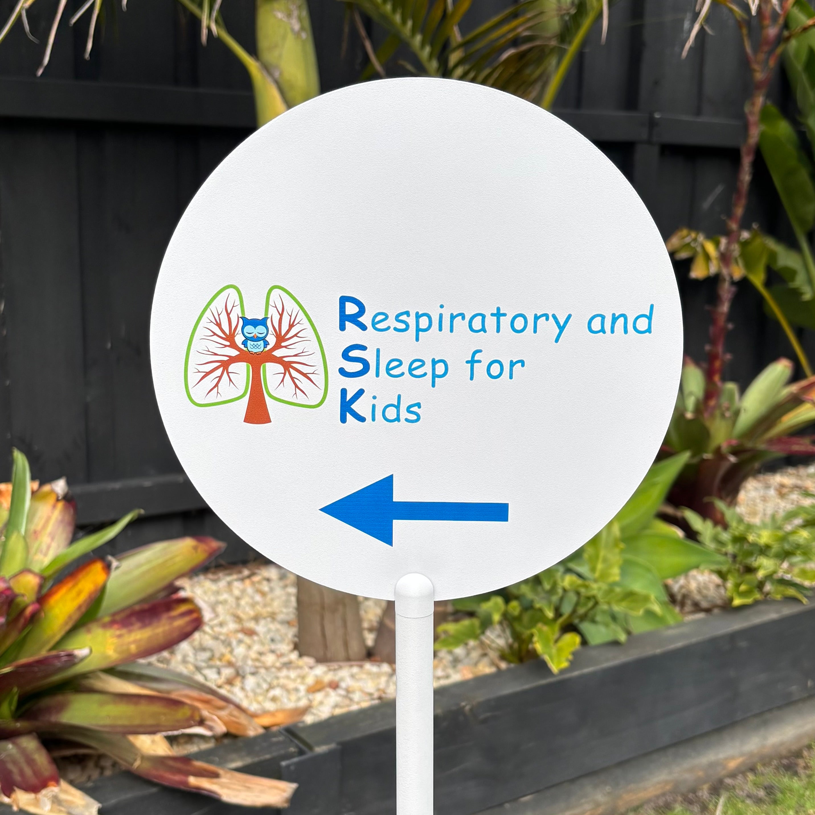 Custom round outdoor directional business sign with full colour logo and arrow, personalised freestanding wayfinding signage for clinics, salons and businesses.