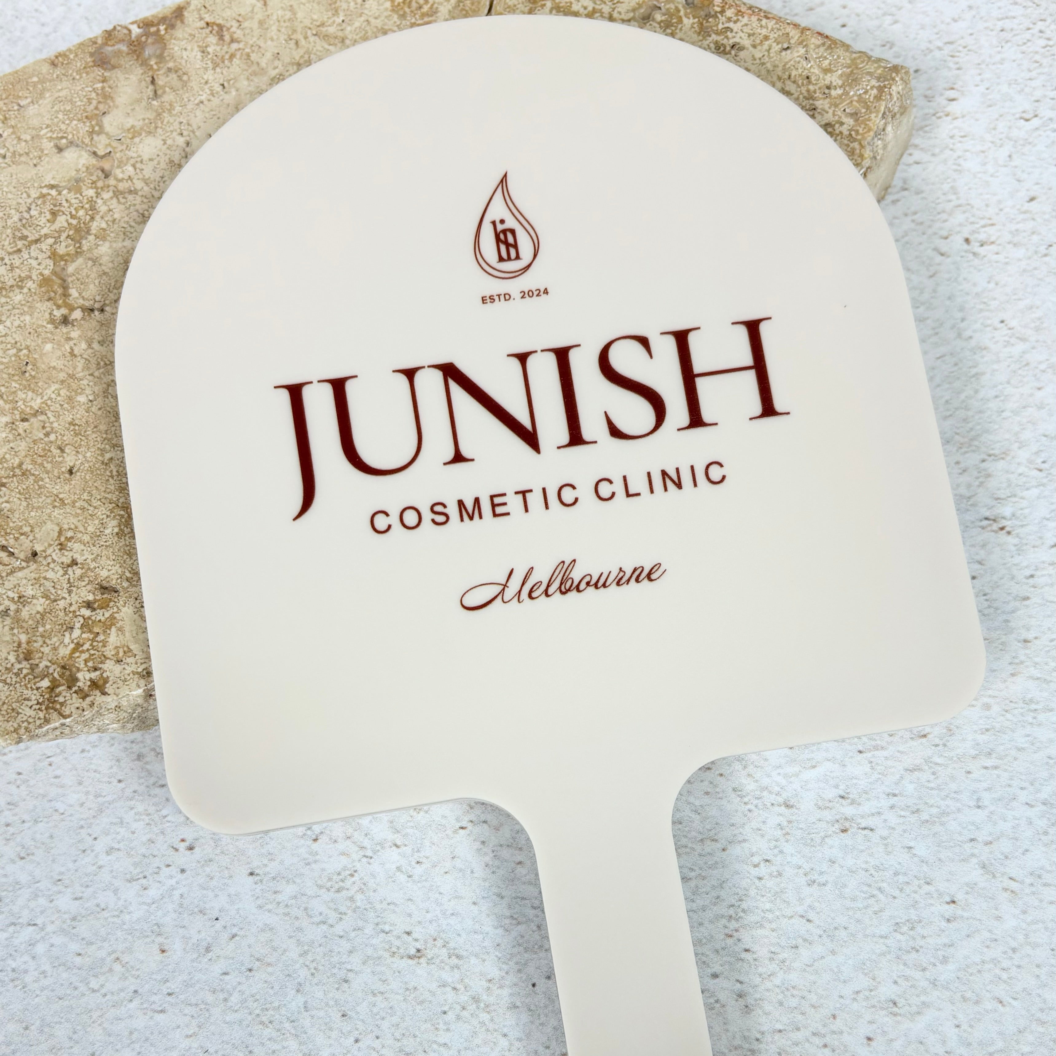 Junish Cosmetic Clinic logo on large arched mirror