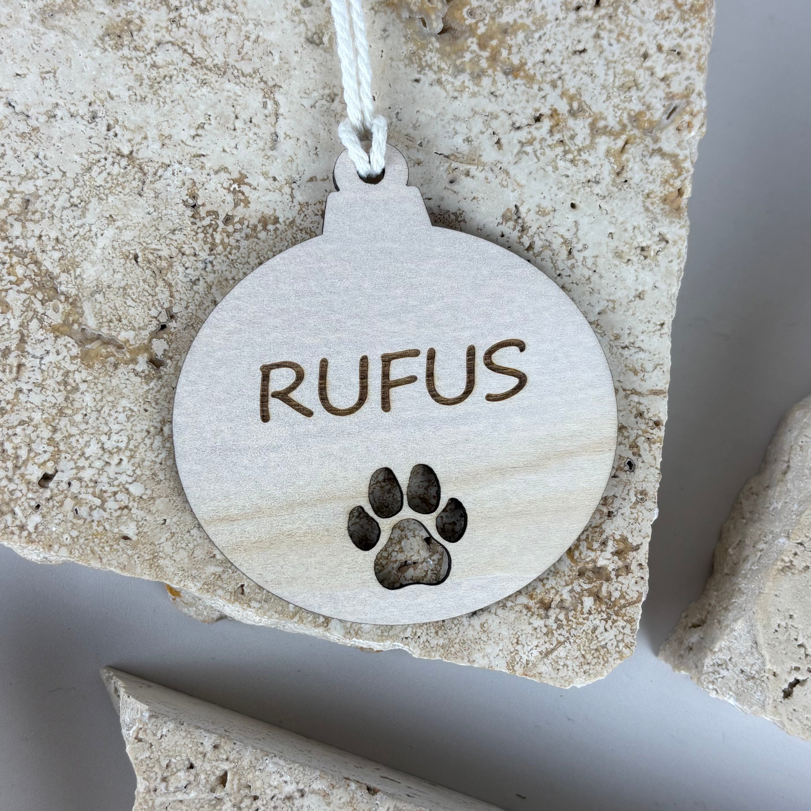 Personalised wooden Christmas bauble engraved with the name “Rufus” and paw print, custom pet Christmas ornament, natural wood keepsake decoration.